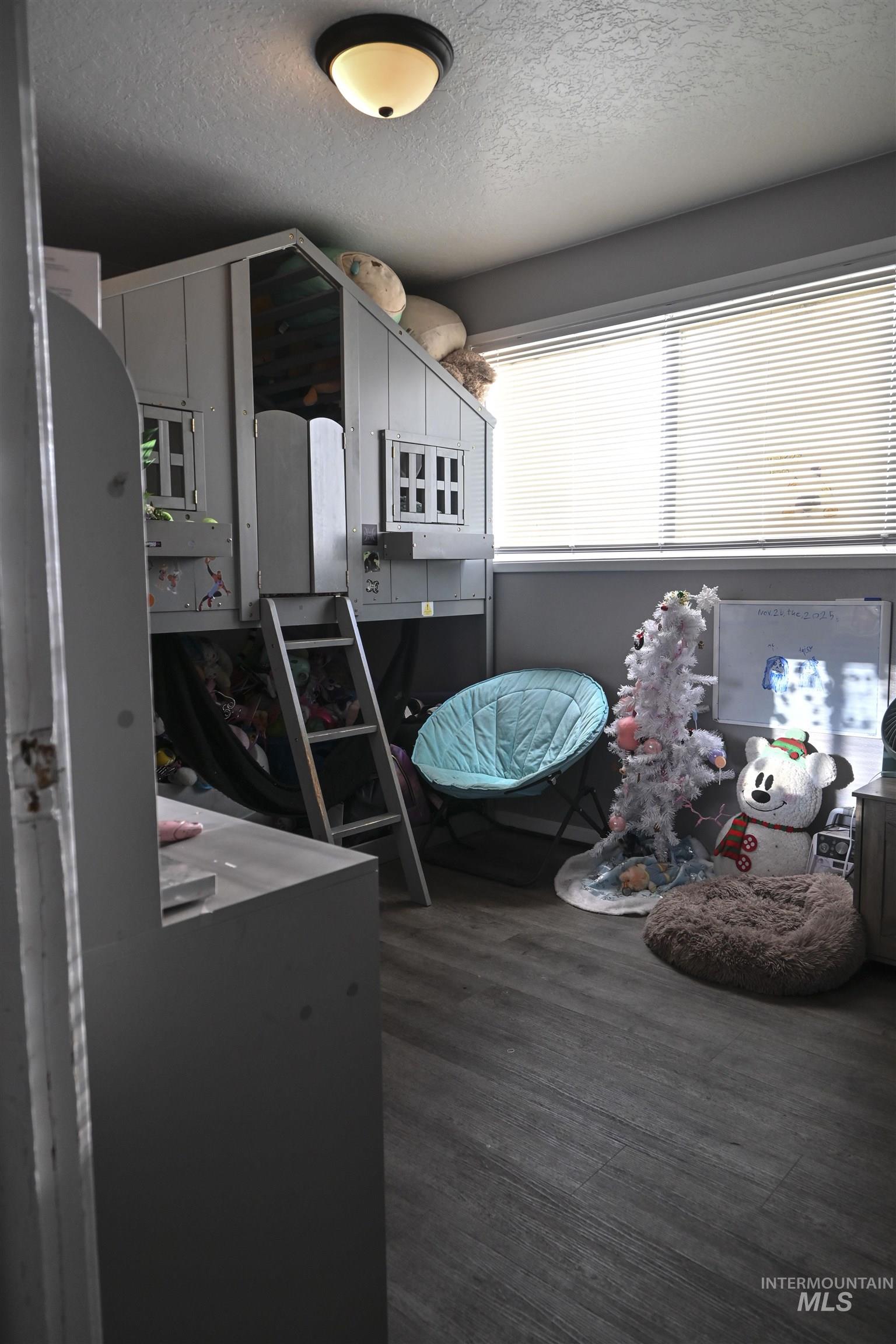 Dining area with a textured ceiling and dark wood-style floors