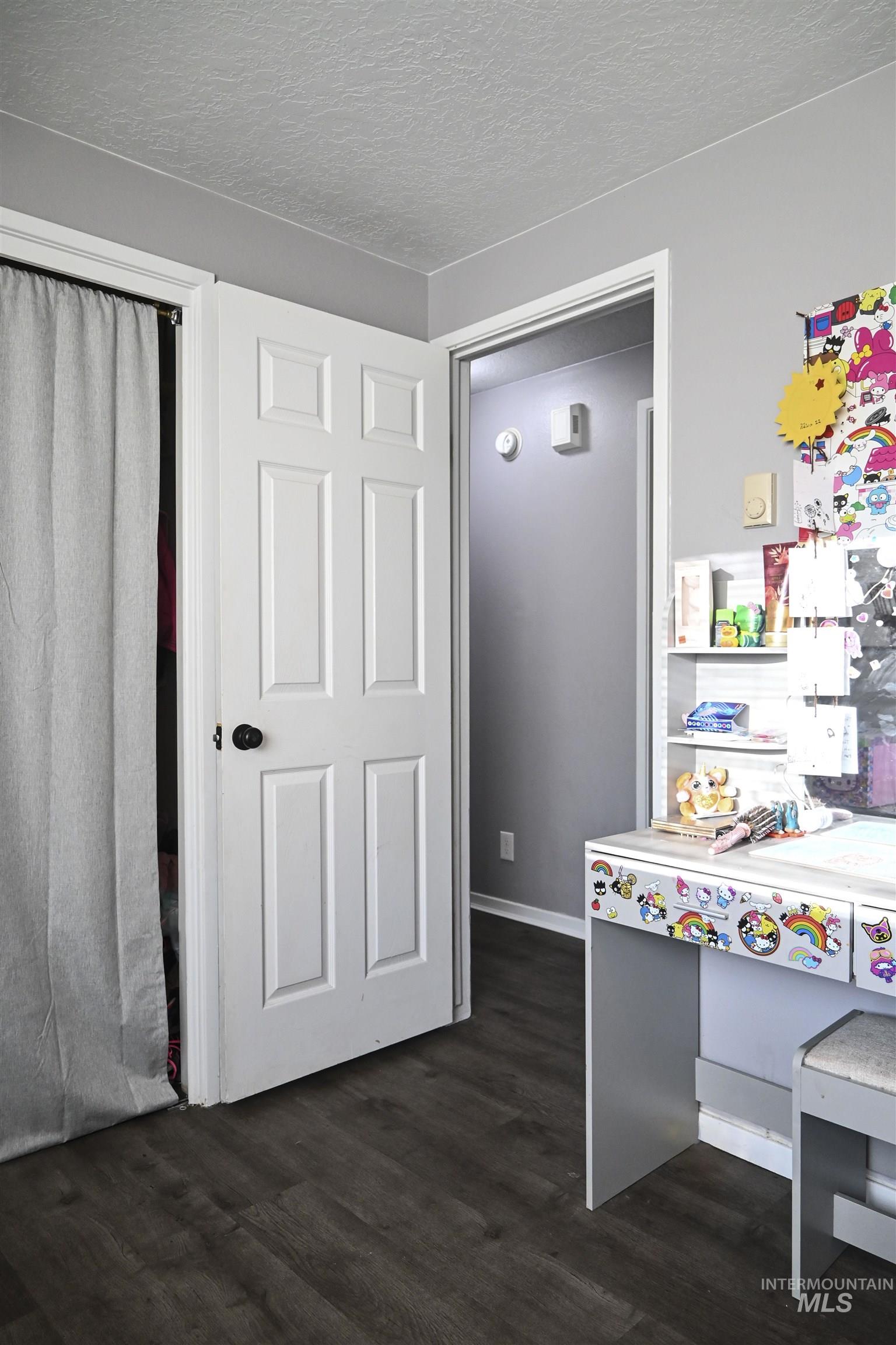 Interior space with dark wood-style floors and a textured ceiling