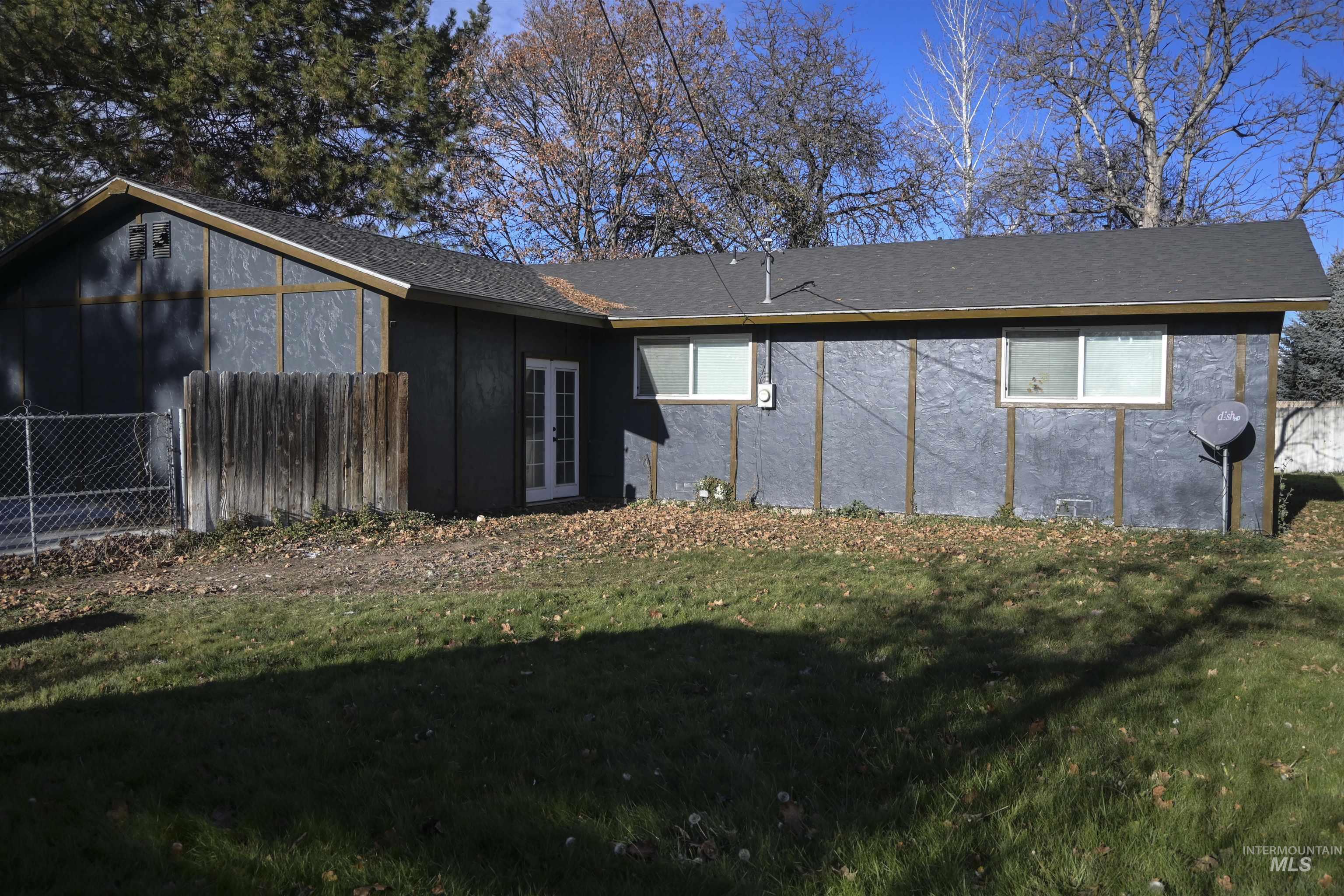 Back of house with french doors, a shingled roof, and stucco siding