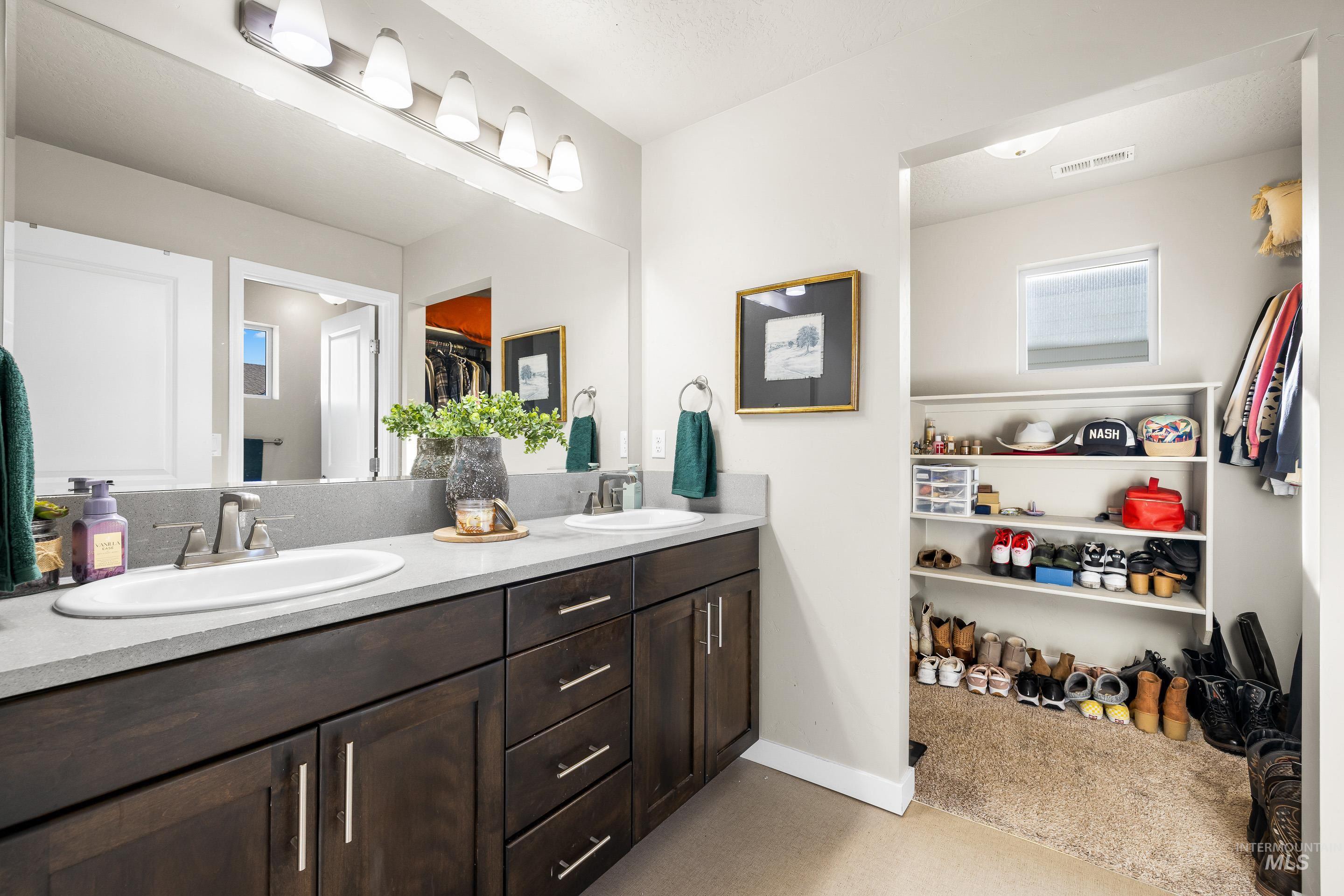 Full bathroom with a spacious closet and double vanity