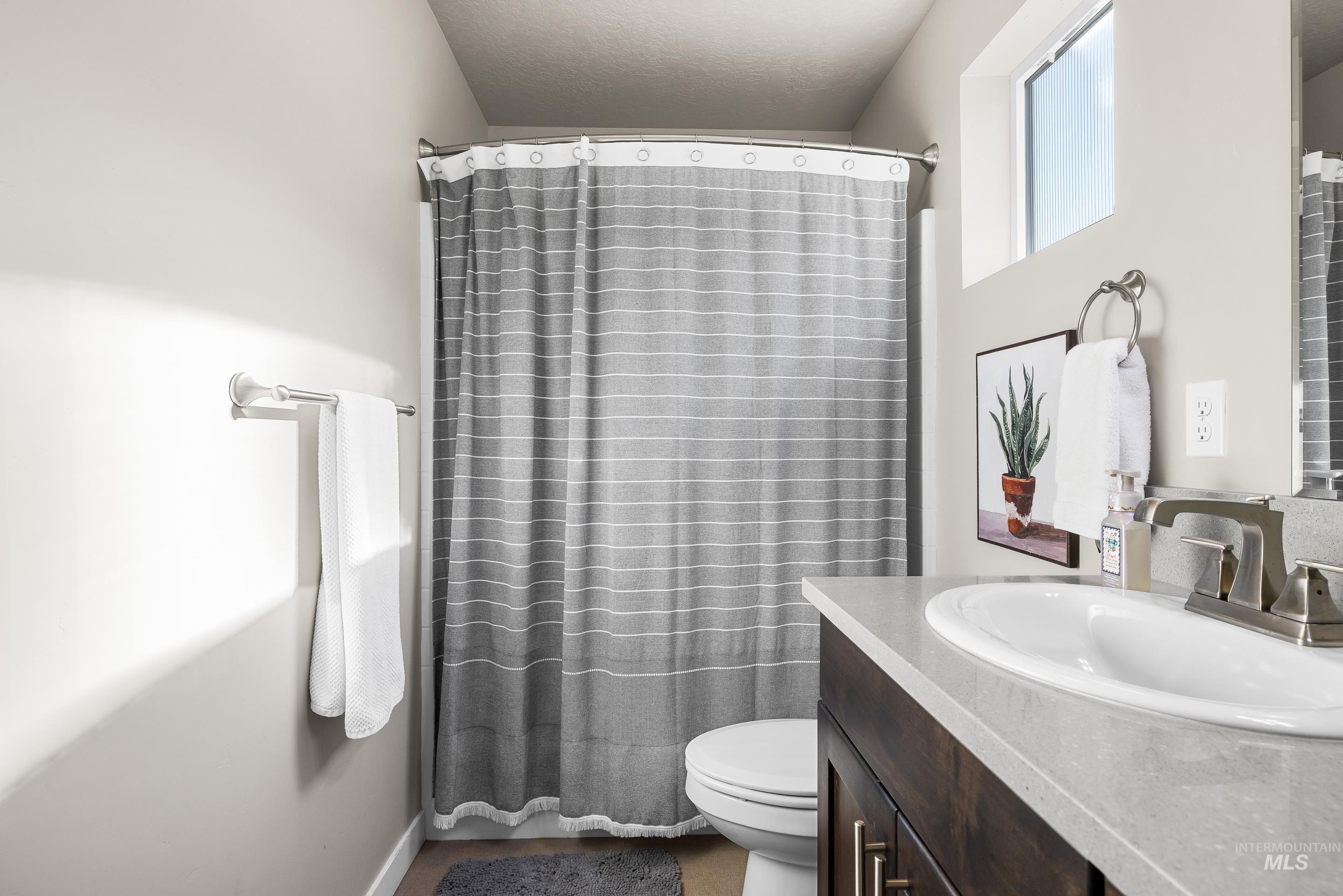 Bathroom featuring curtained shower and vanity