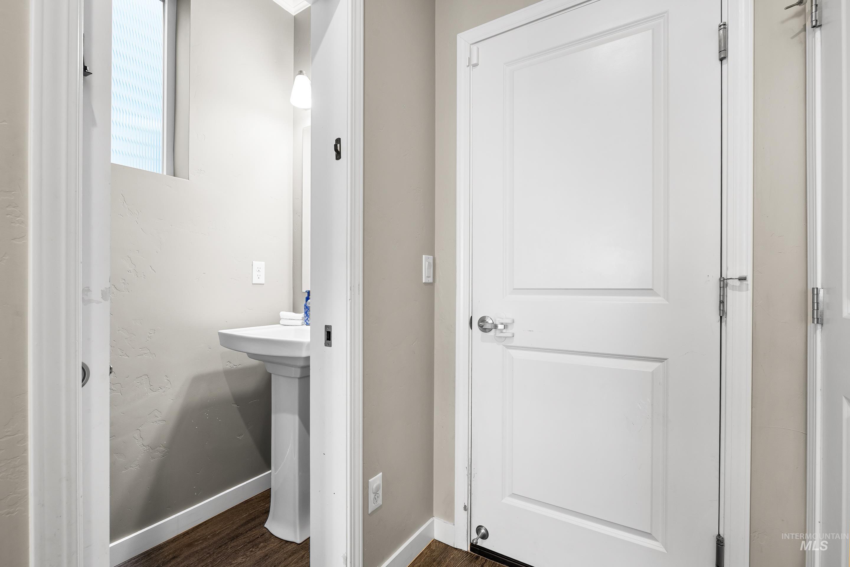 Bathroom featuring baseboards and dark wood-style flooring
