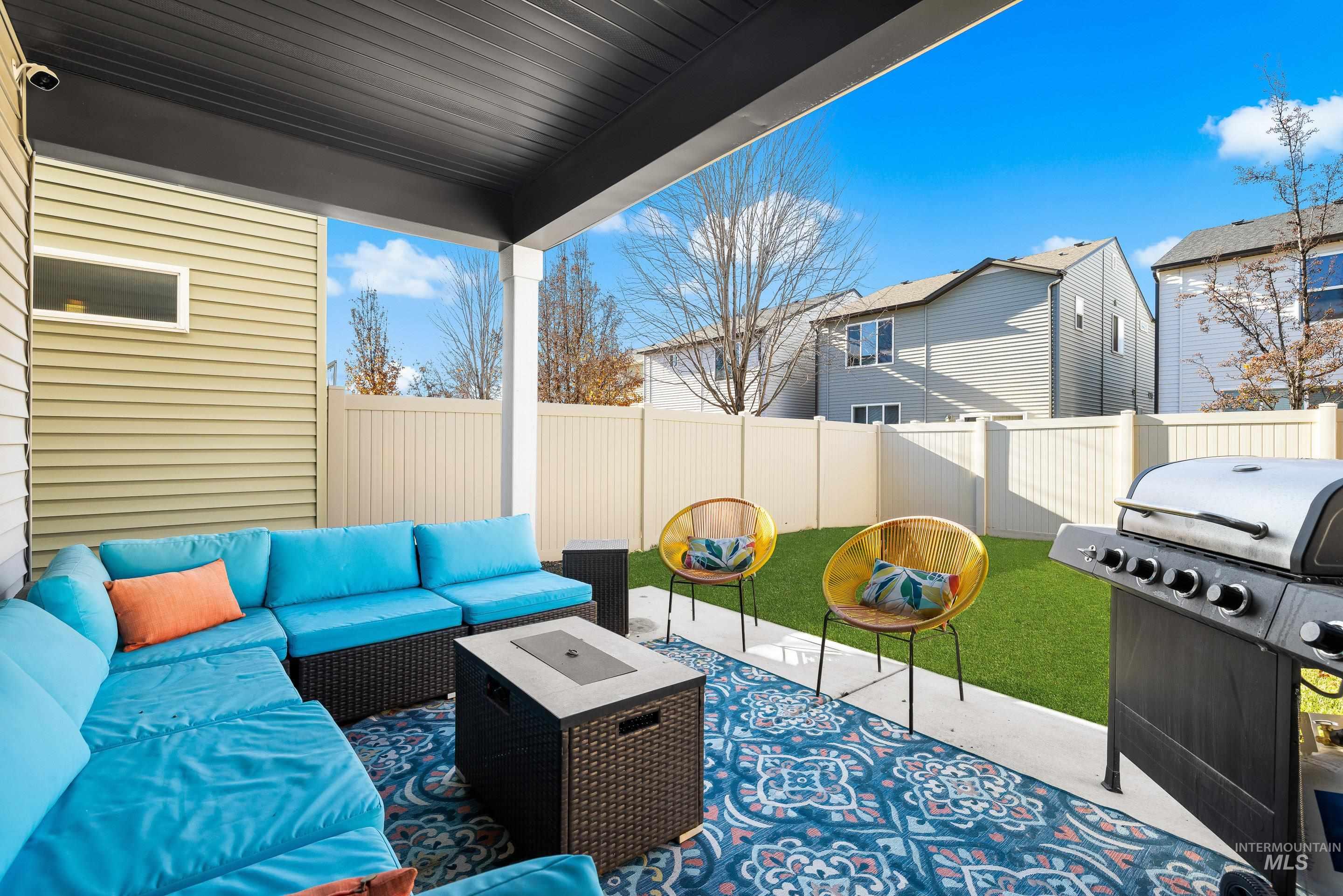 Fenced backyard featuring a patio area, grilling area, and an outdoor hangout area