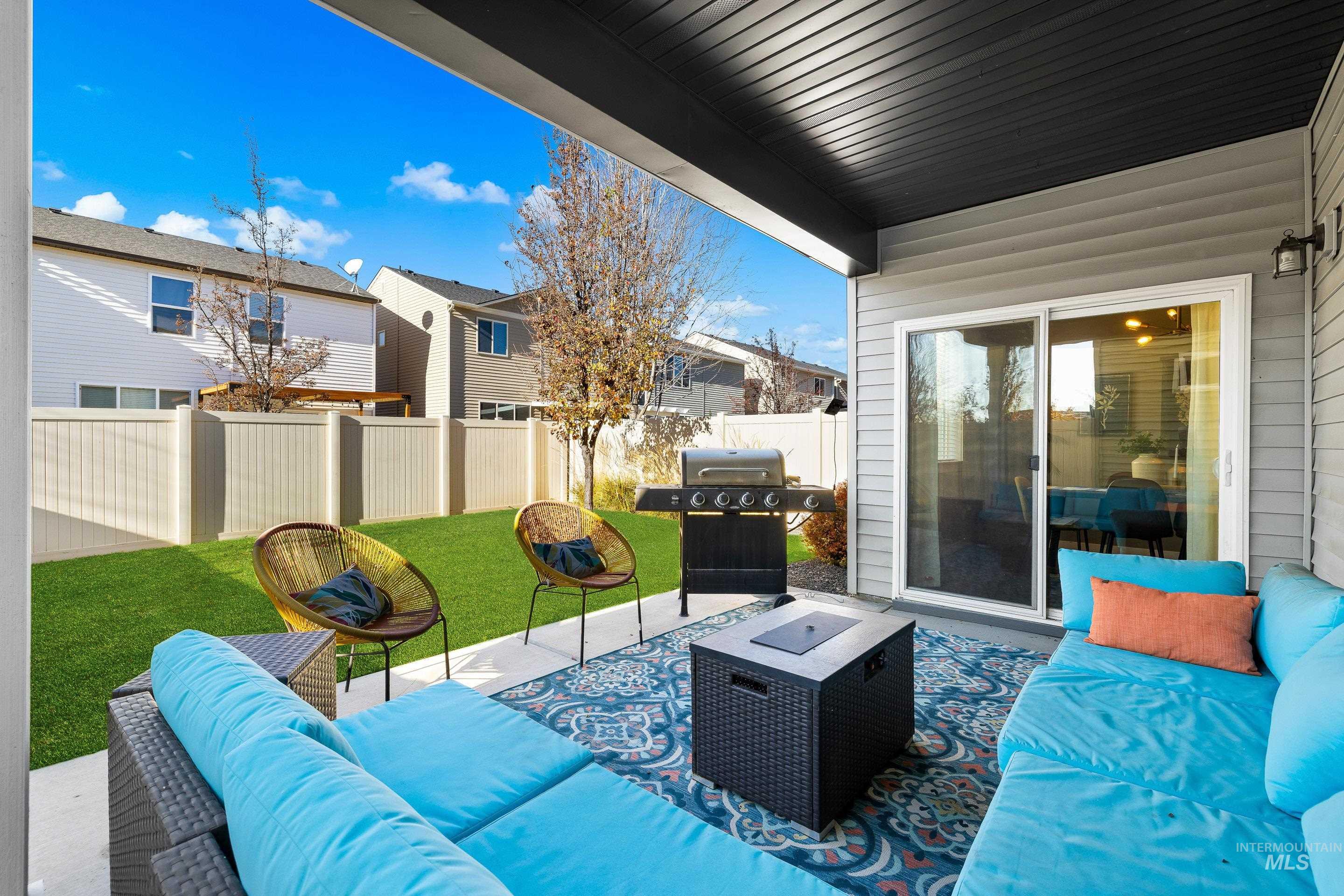 Fenced backyard with an outdoor hangout area, a patio area, and a grill