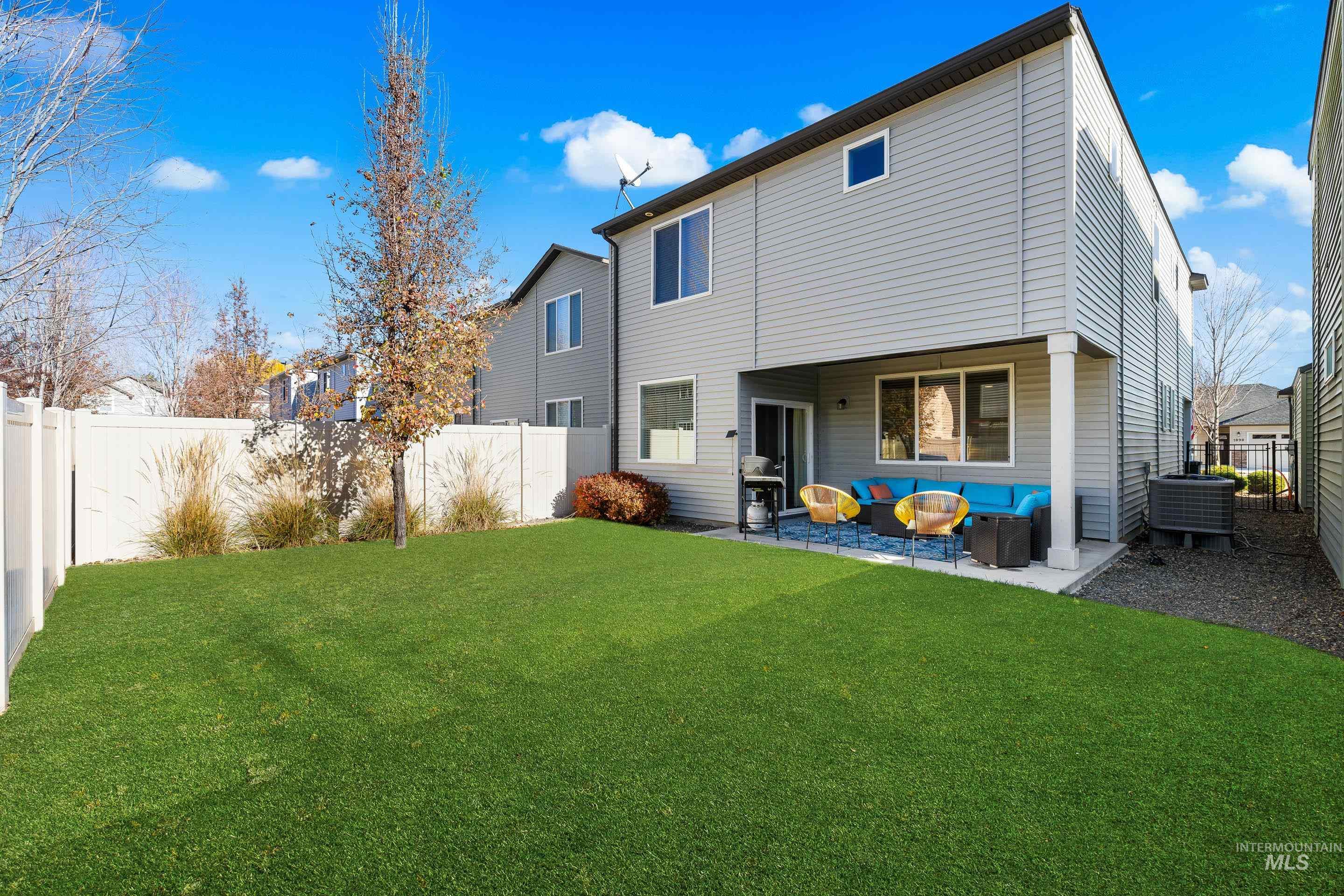 Back of property with a fenced backyard, an outdoor living space, and a patio area