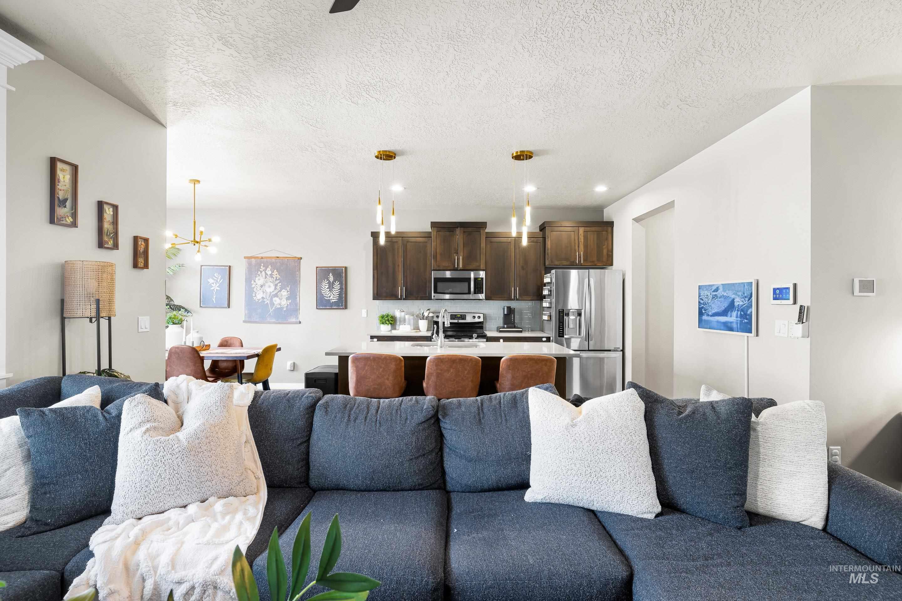Living room with a chandelier, a textured ceiling, and recessed lighting