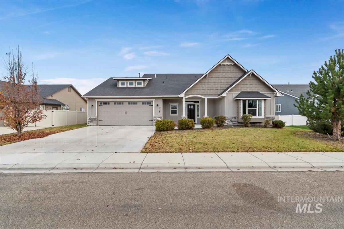 Craftsman-style home featuring driveway, stone siding, an attached garage, and board and batten siding