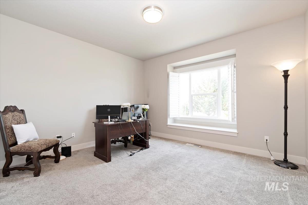Office area featuring light carpet and baseboards