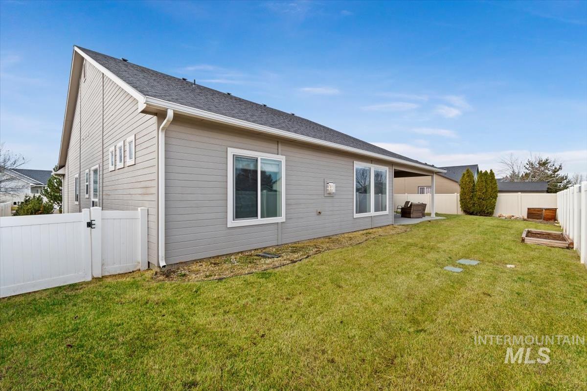 Rear view of property with a fenced backyard, a patio area, a gate, and a shingled roof
