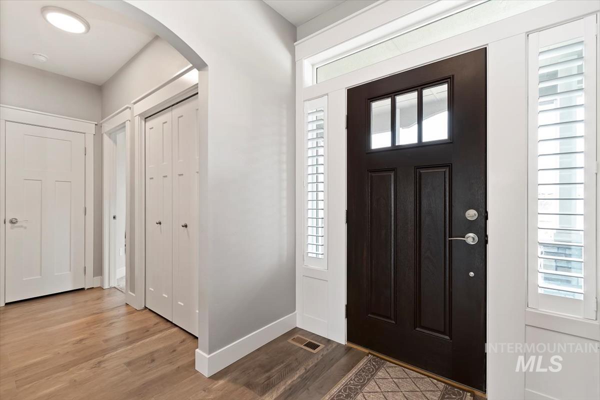 Entrance foyer featuring arched walkways and light wood-style floors