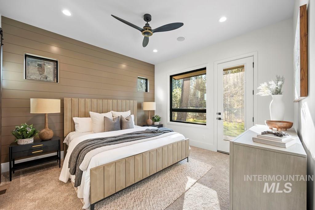 Primary Bedroom with wooden walls, light carpet, recessed lighting, access to outside, and a ceiling fan