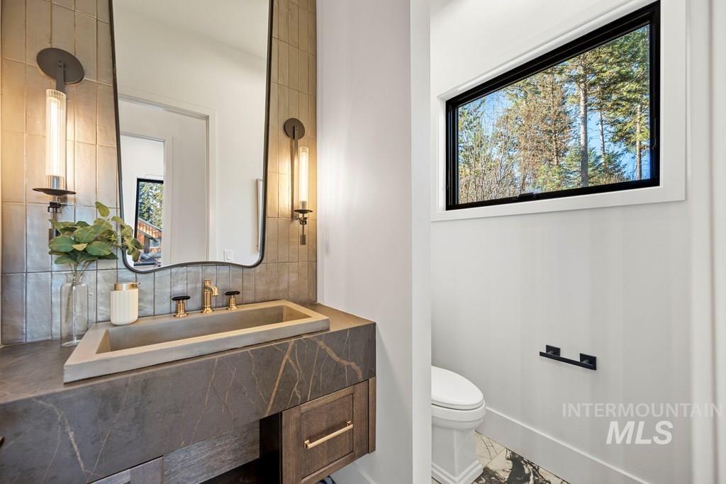 Half bathroom featuring vanity and decorative backsplash - Main Floor