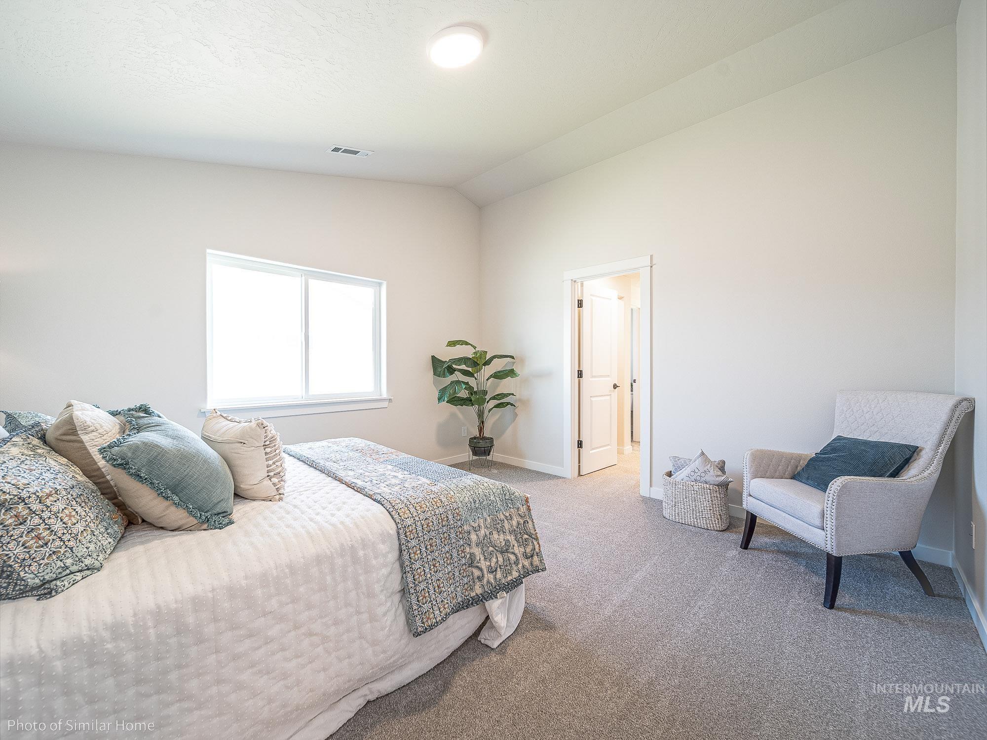 Master Bedroom featuring vaulted ceiling and carpet floors