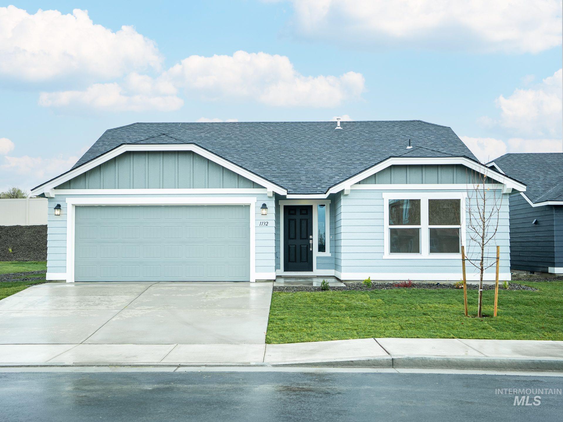 Ranch-style home with a shingled roof, board and batten siding, a front yard, and an attached garage
