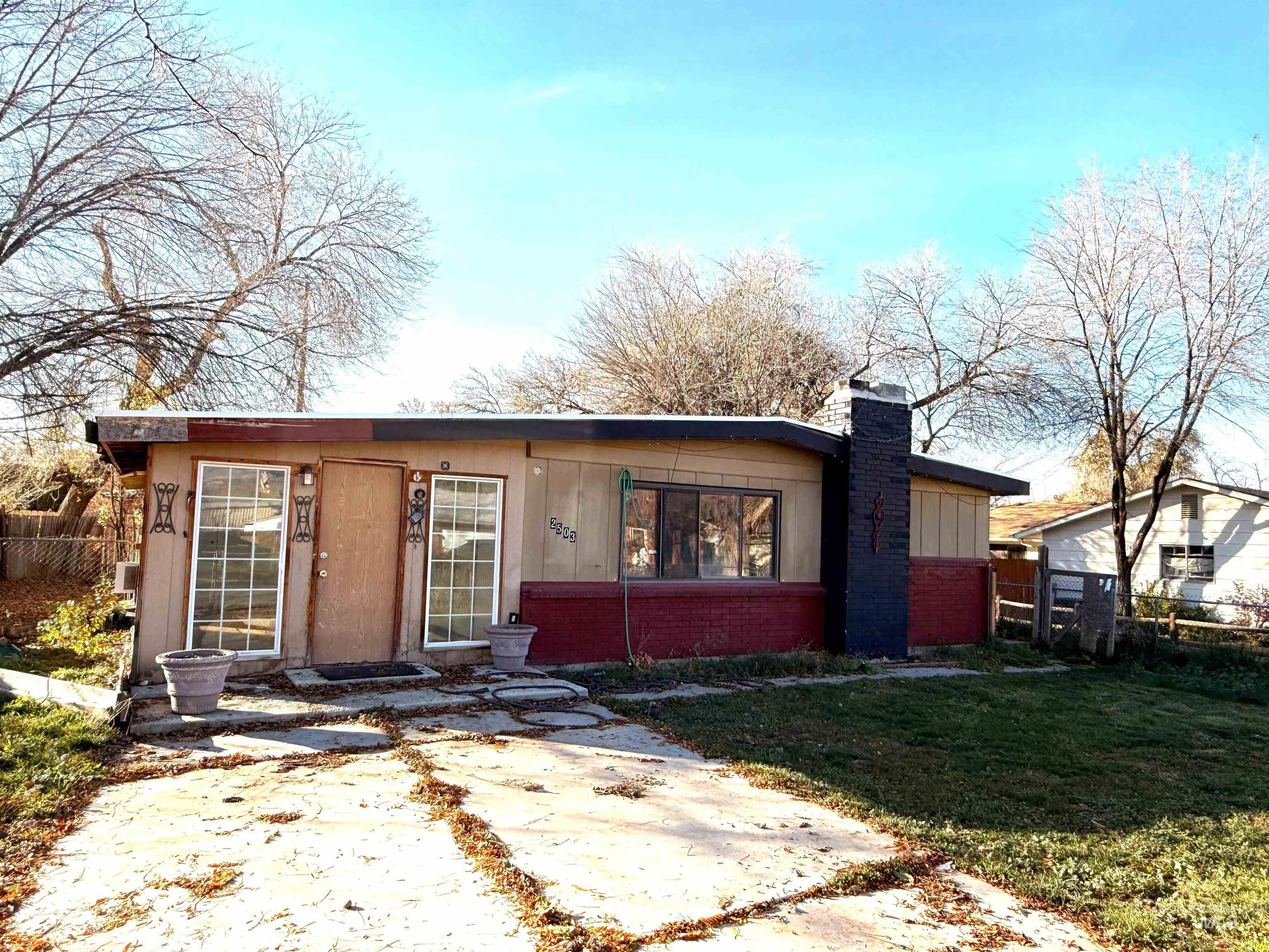View of front facade featuring brick siding and a chimney