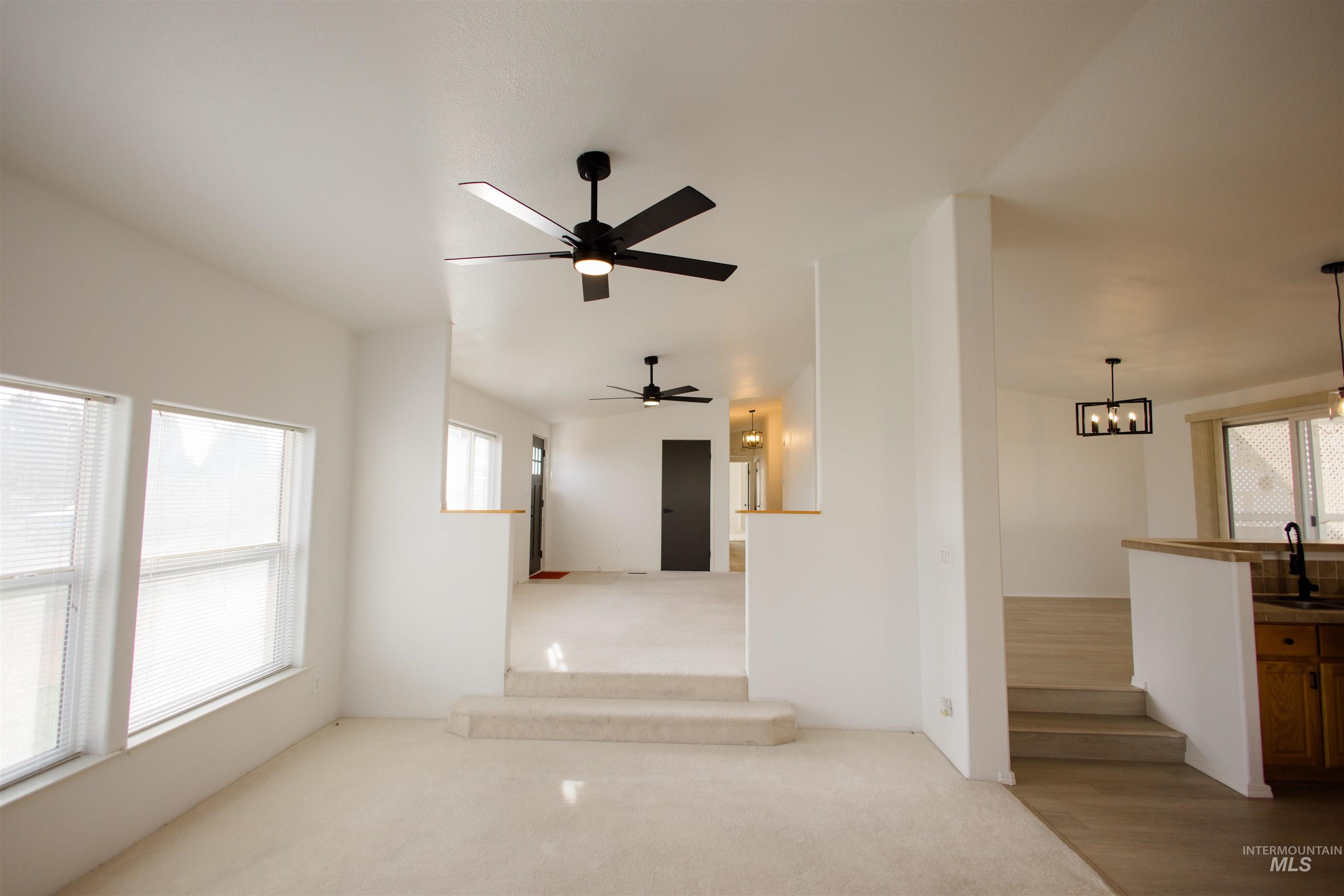 Carpeted empty room with a sink and a ceiling fan