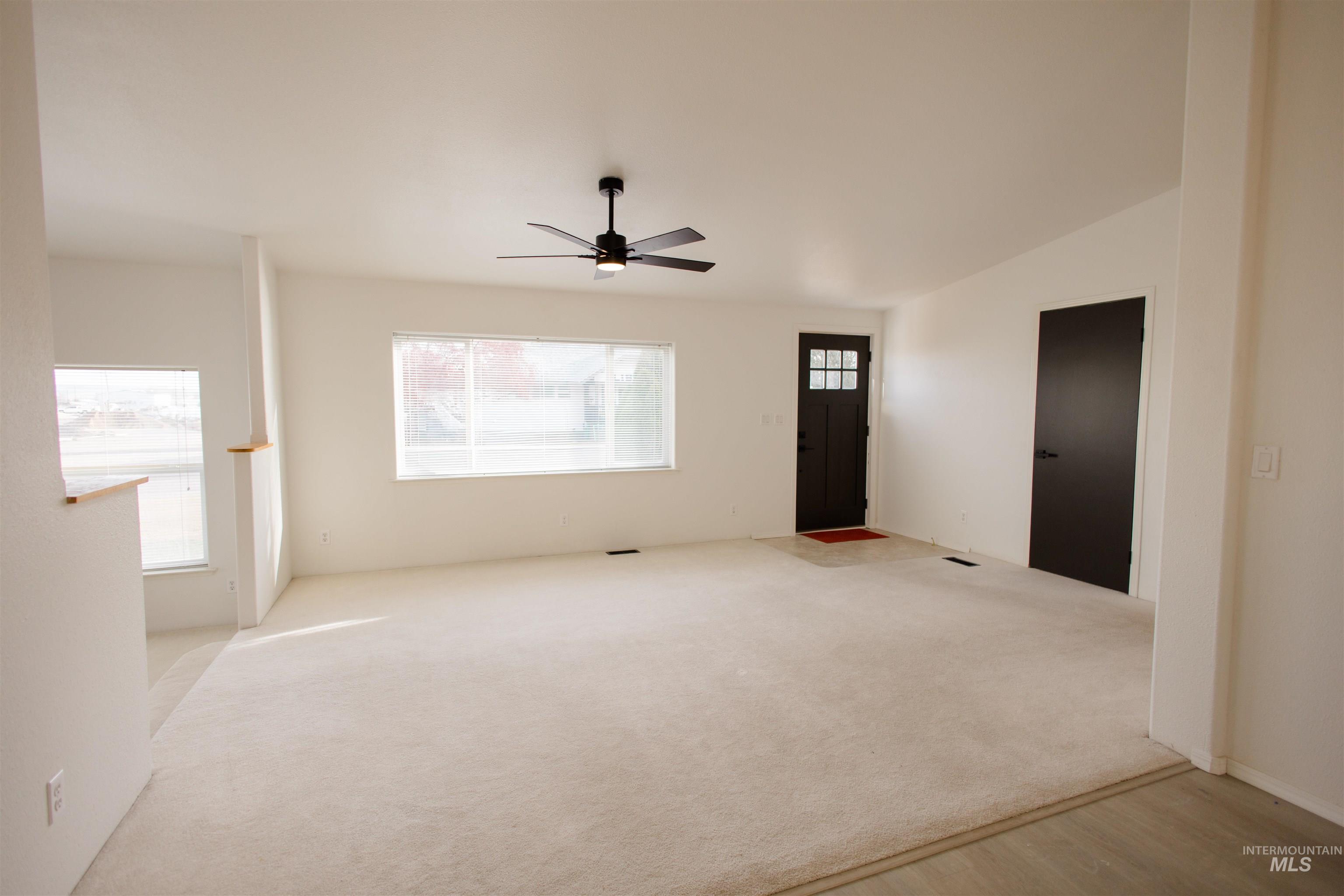 Unfurnished room featuring ceiling fan and carpet