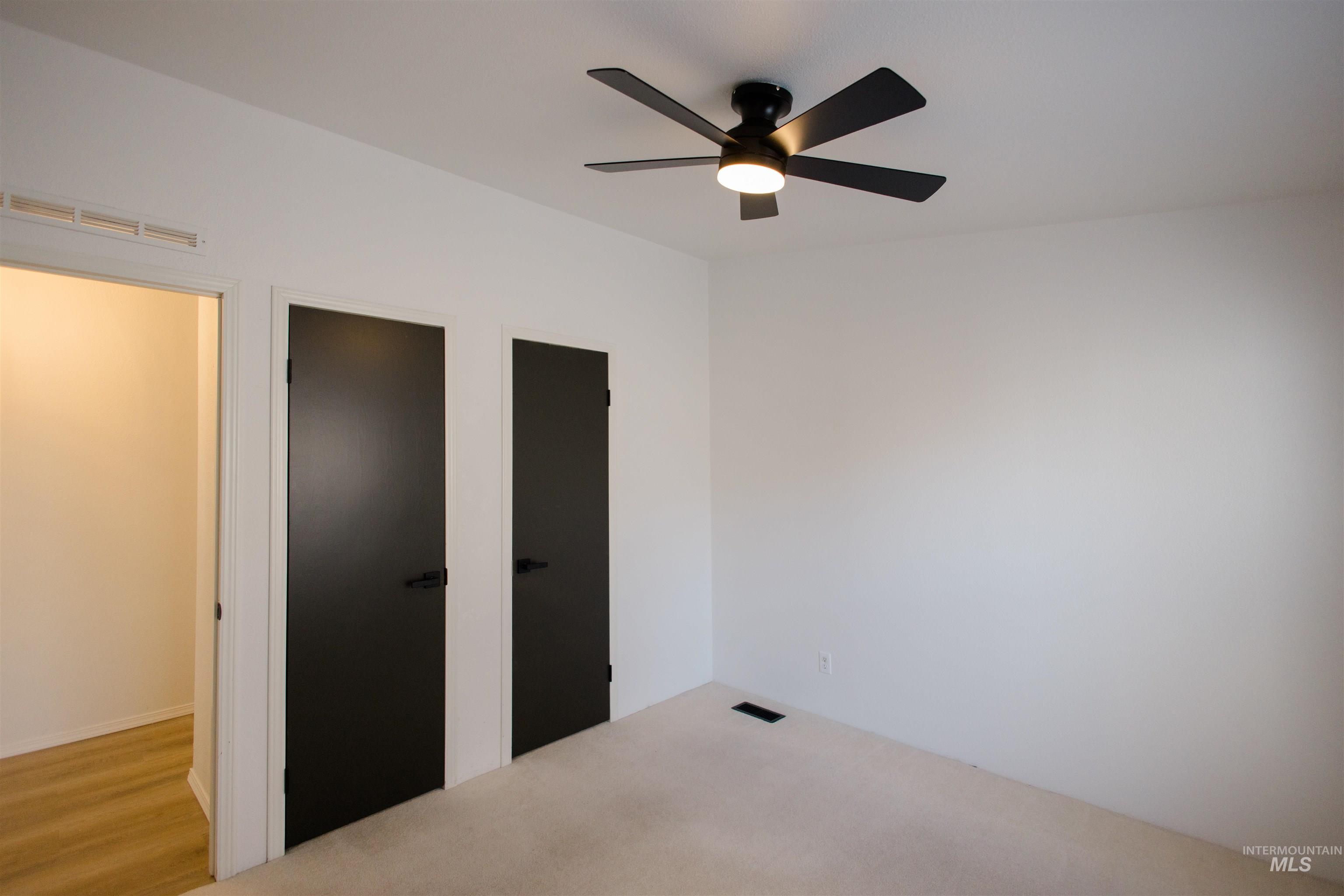 Unfurnished bedroom featuring two closets and ceiling fan