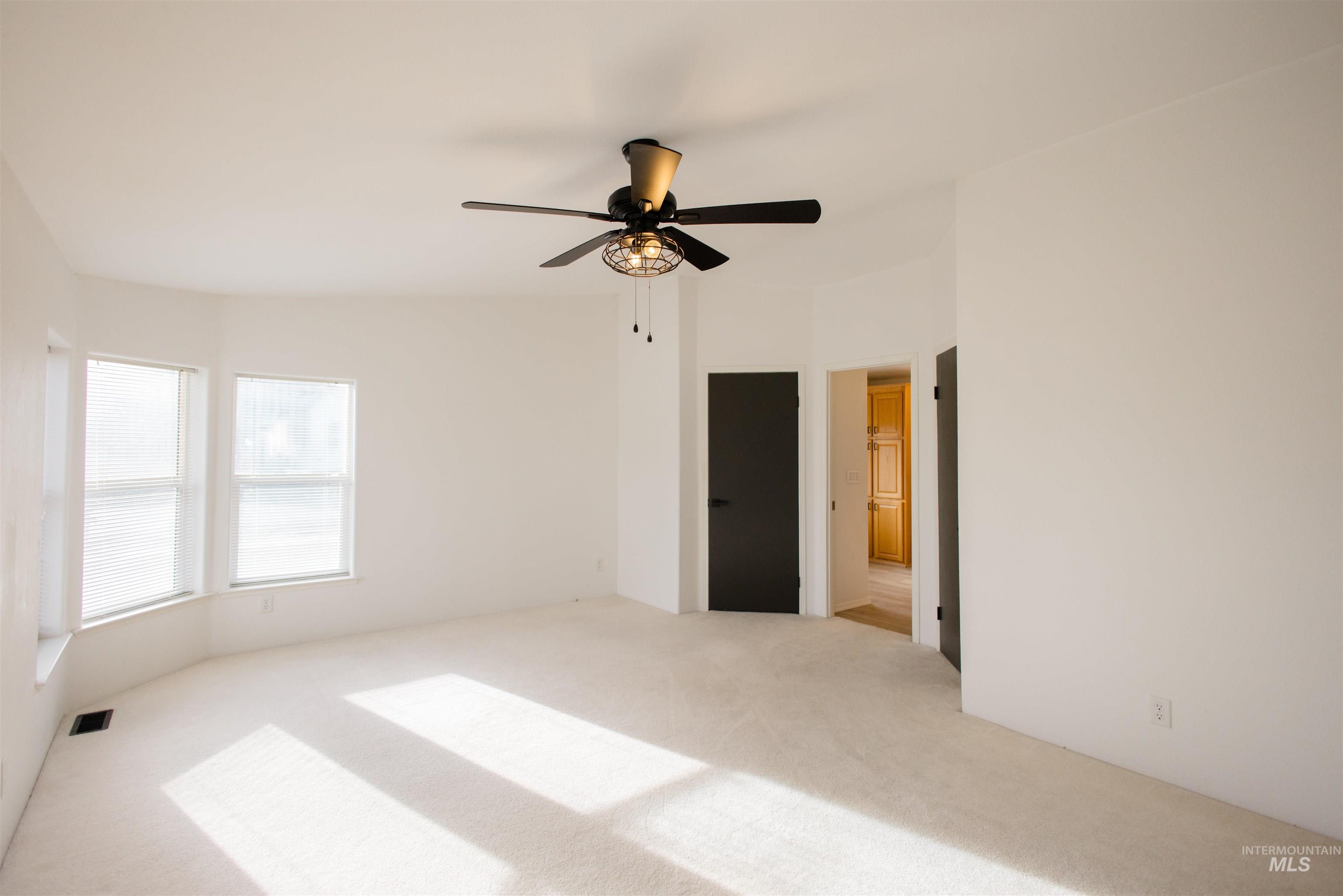 Spare room featuring ceiling fan and carpet flooring
