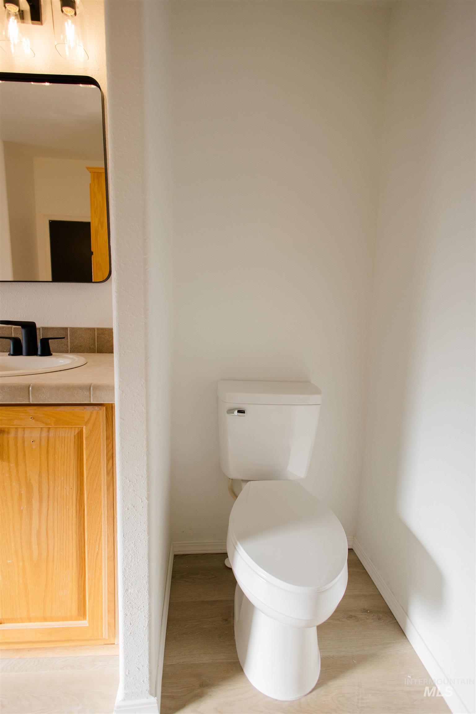 Half bath featuring vanity and light wood finished floors