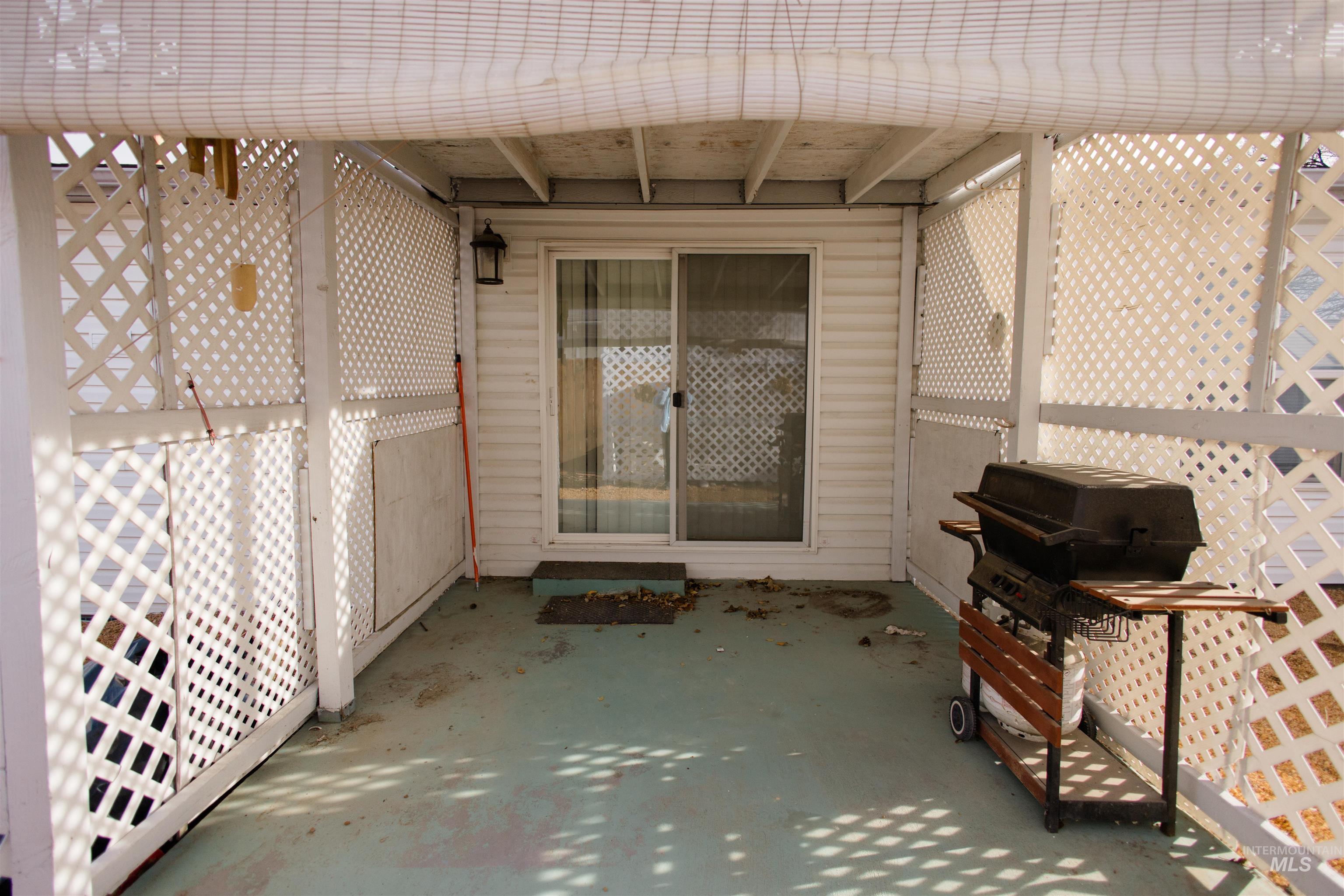 View of patio with a grill