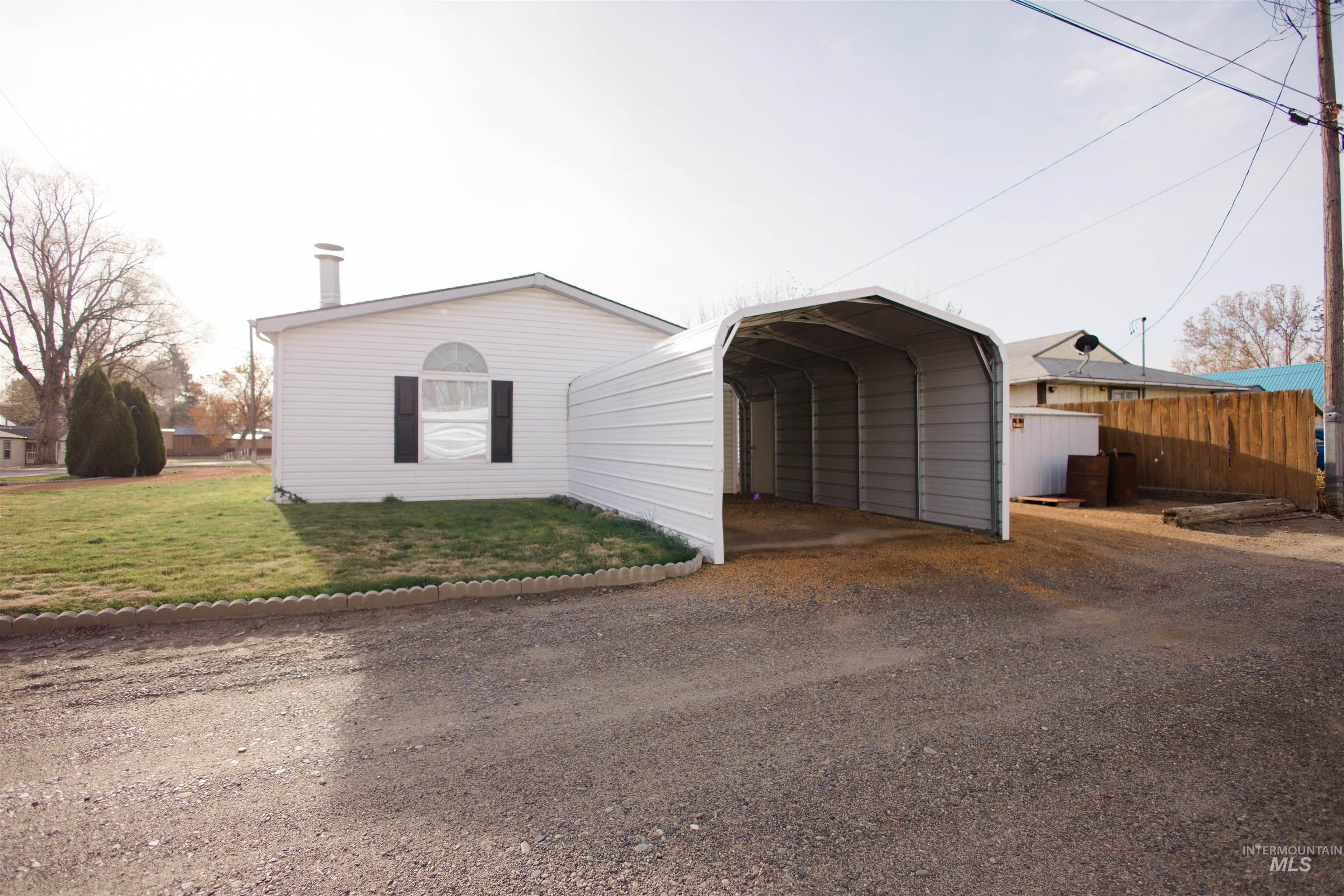 View of front facade featuring a detached carport and driveway