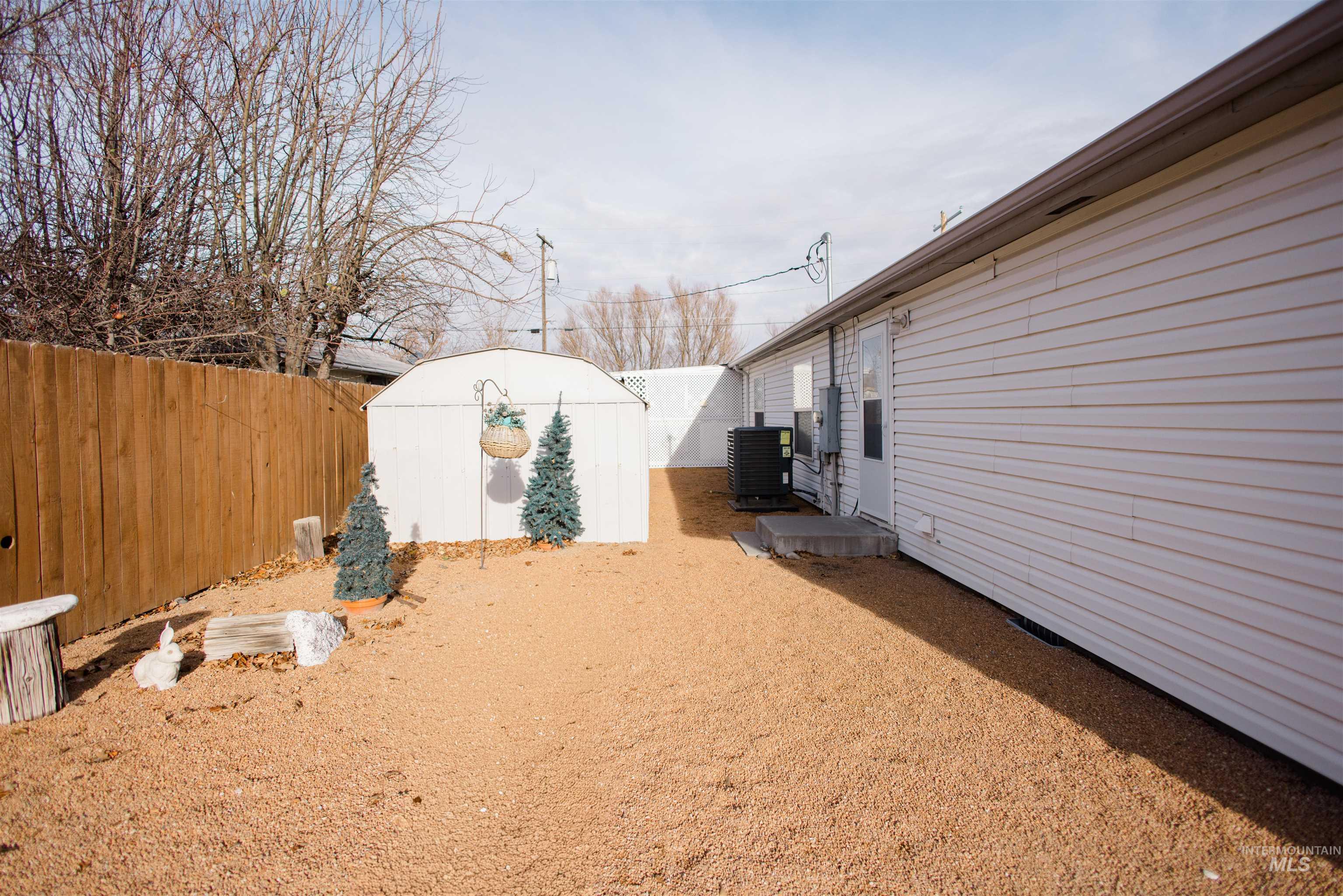 Fenced backyard featuring a storage unit