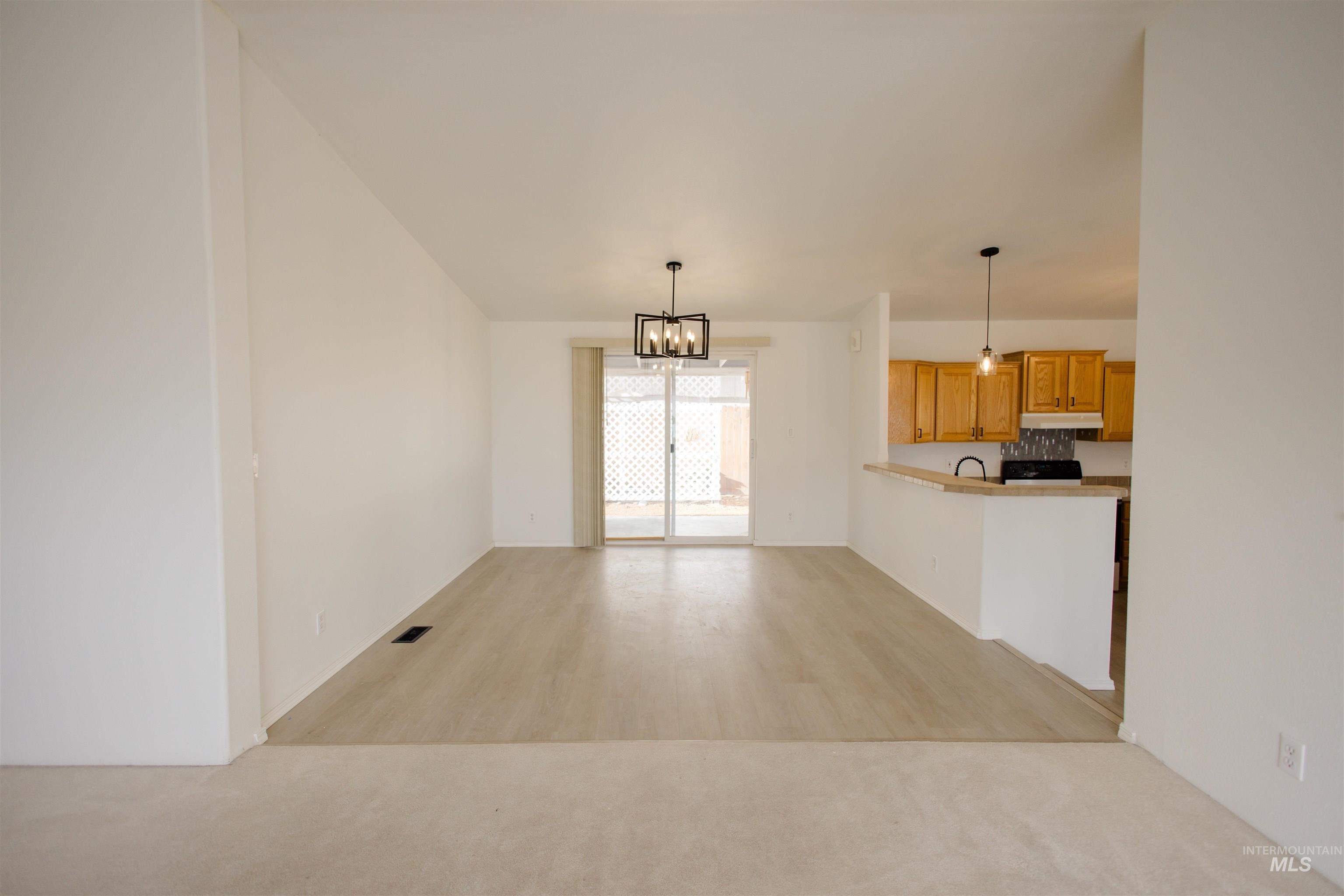Unfurnished living room featuring a chandelier and light wood finished floors