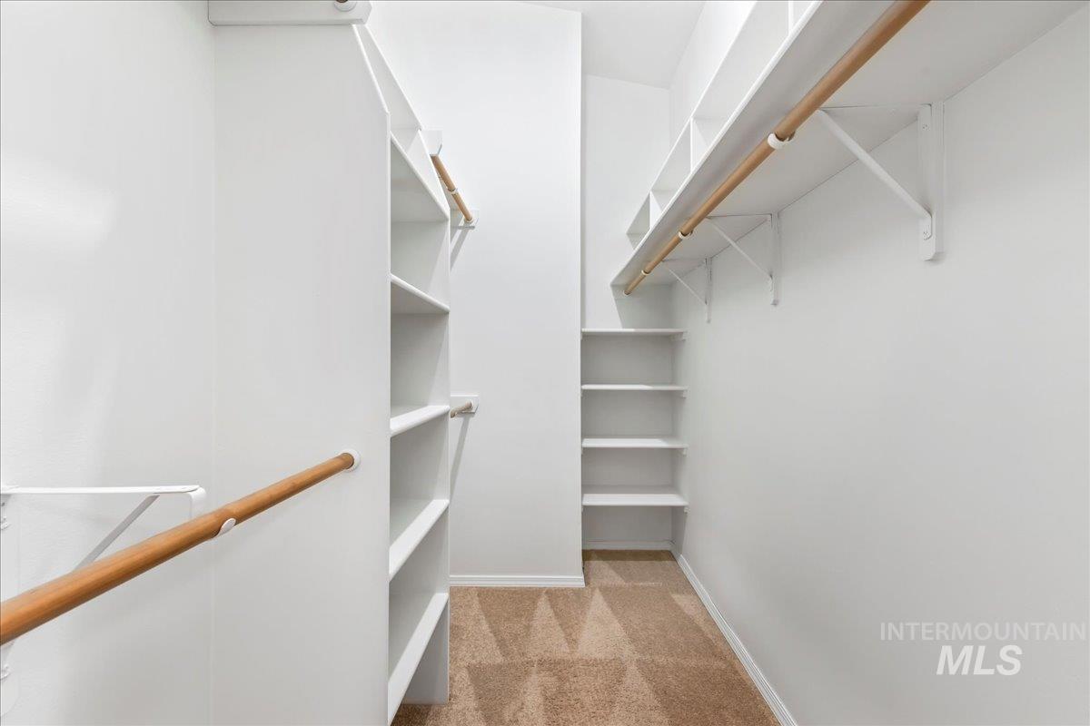 Spacious closet with light carpet