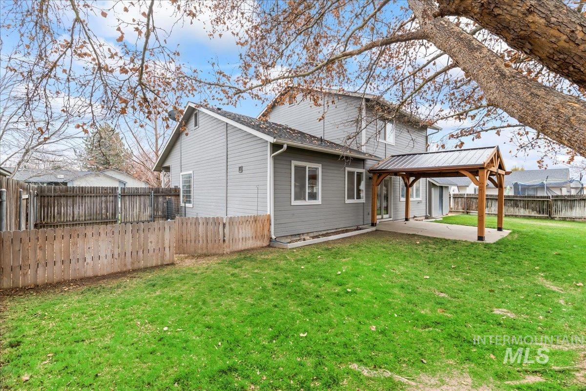 Back of property with a fenced backyard, a patio, and a gazebo