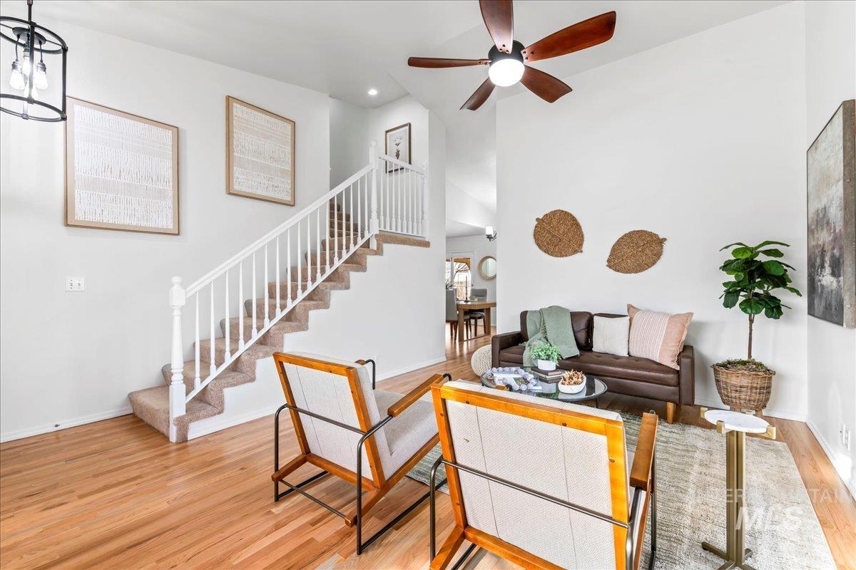 Living room featuring light wood-style flooring, stairway, ceiling fan, and recessed lighting