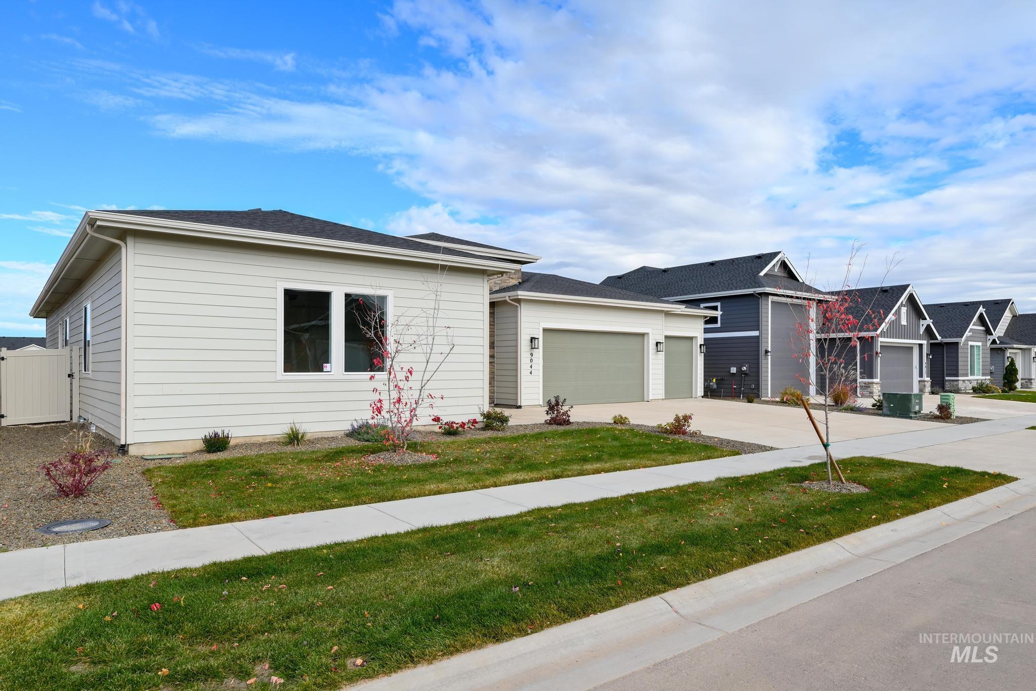 View of front of house featuring an attached garage, driveway, and a front yard
