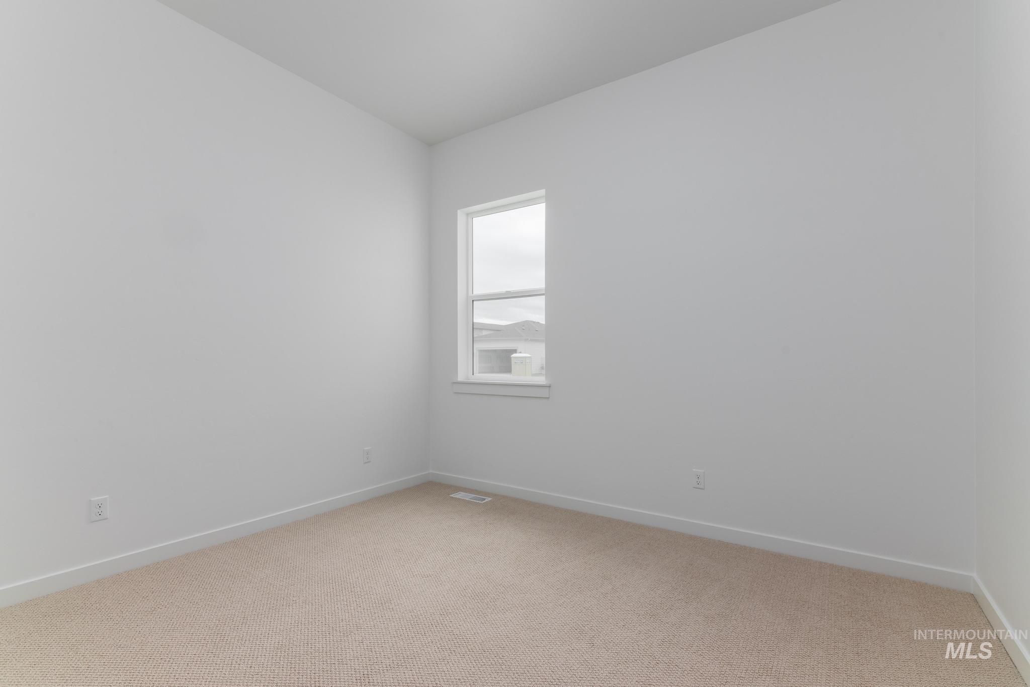 Unfurnished room featuring light colored carpet and baseboards