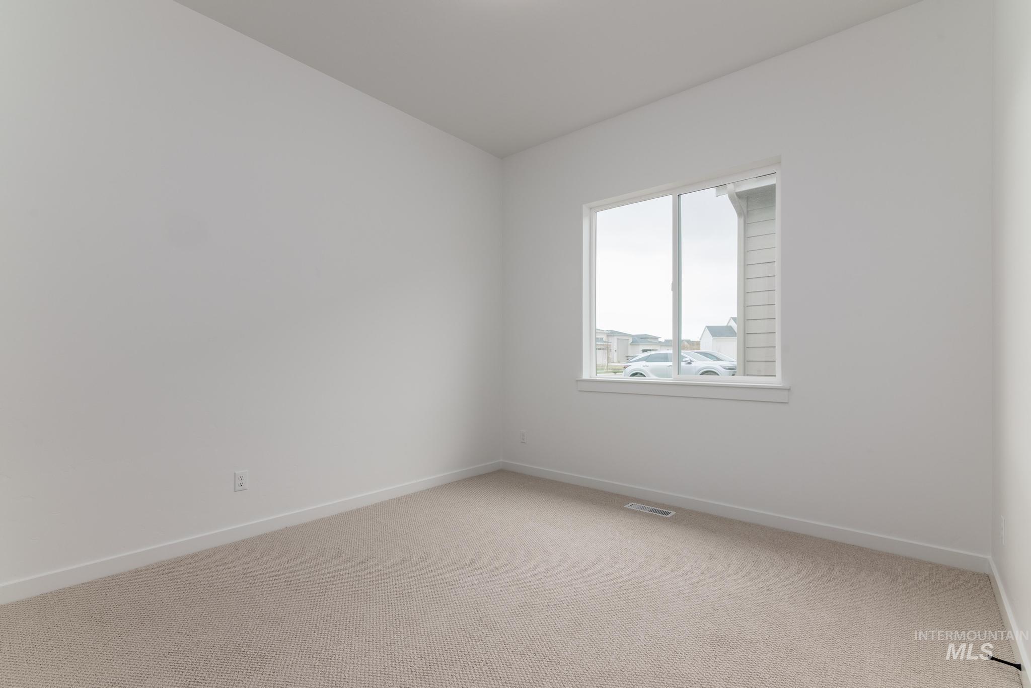 Carpeted empty room with baseboards