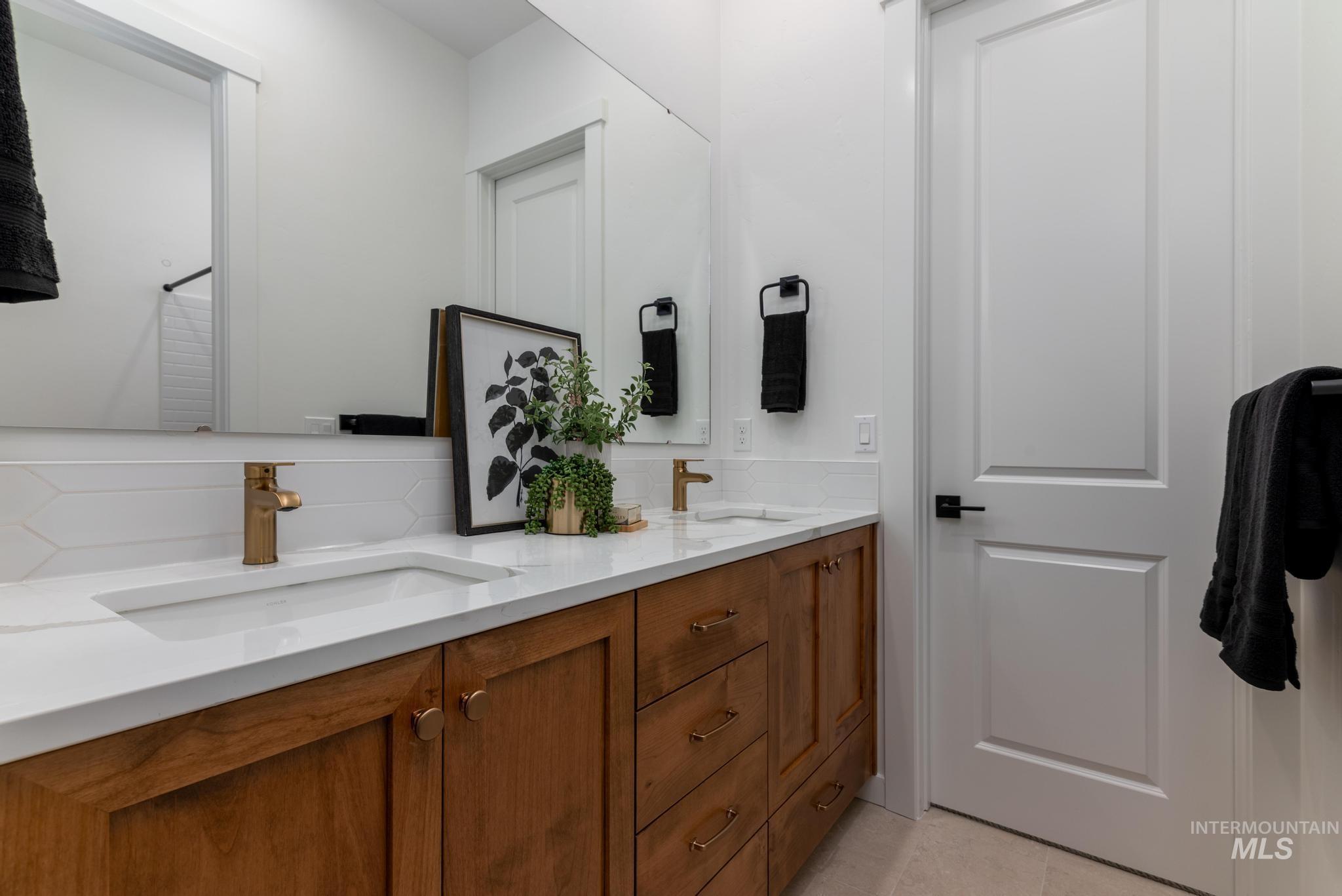 Bathroom featuring tasteful backsplash and double vanity