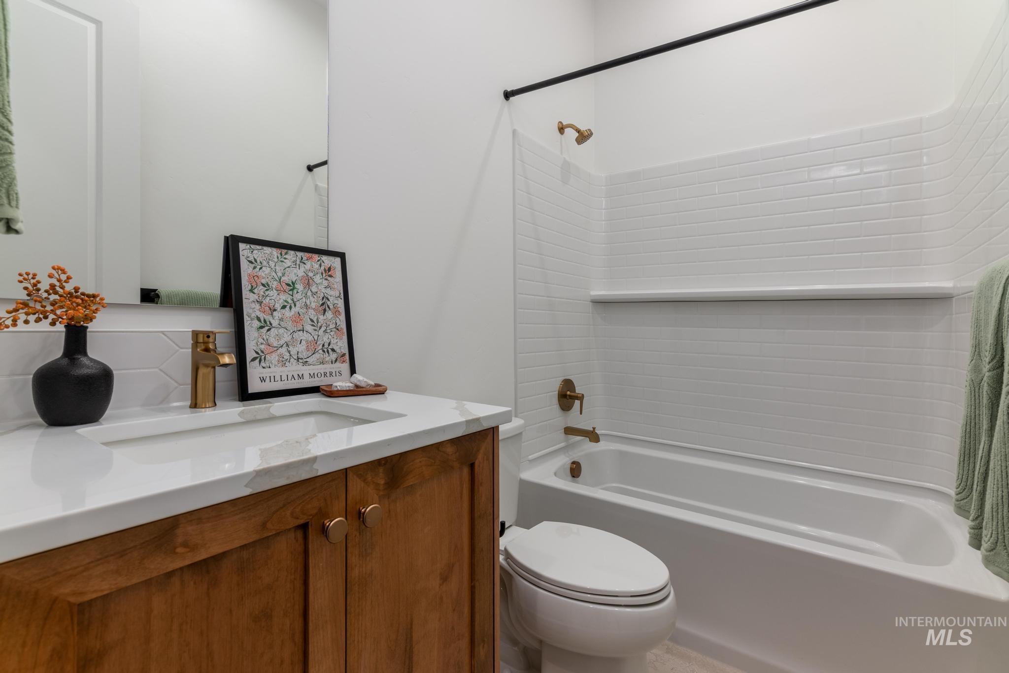 Bathroom featuring  shower combination, vanity, and backsplash