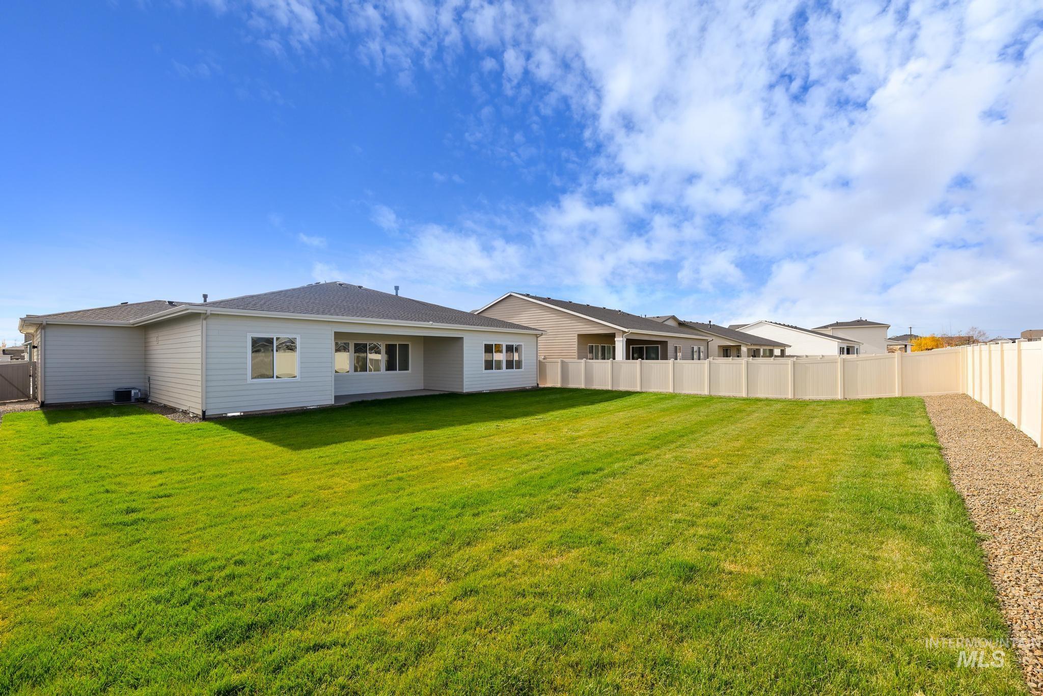 Rear view of house featuring a fenced backyard