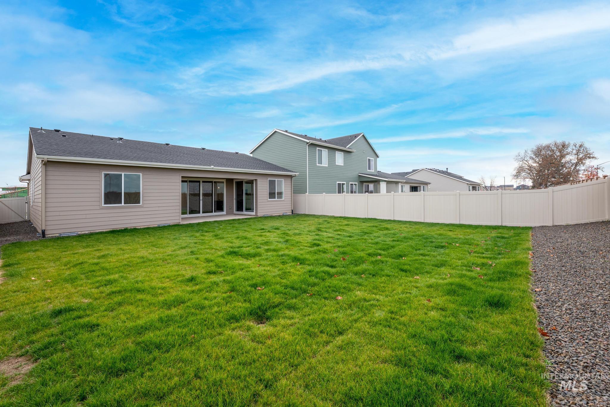 Rear view of house with a patio area, a fenced backyard, and roof with shingles