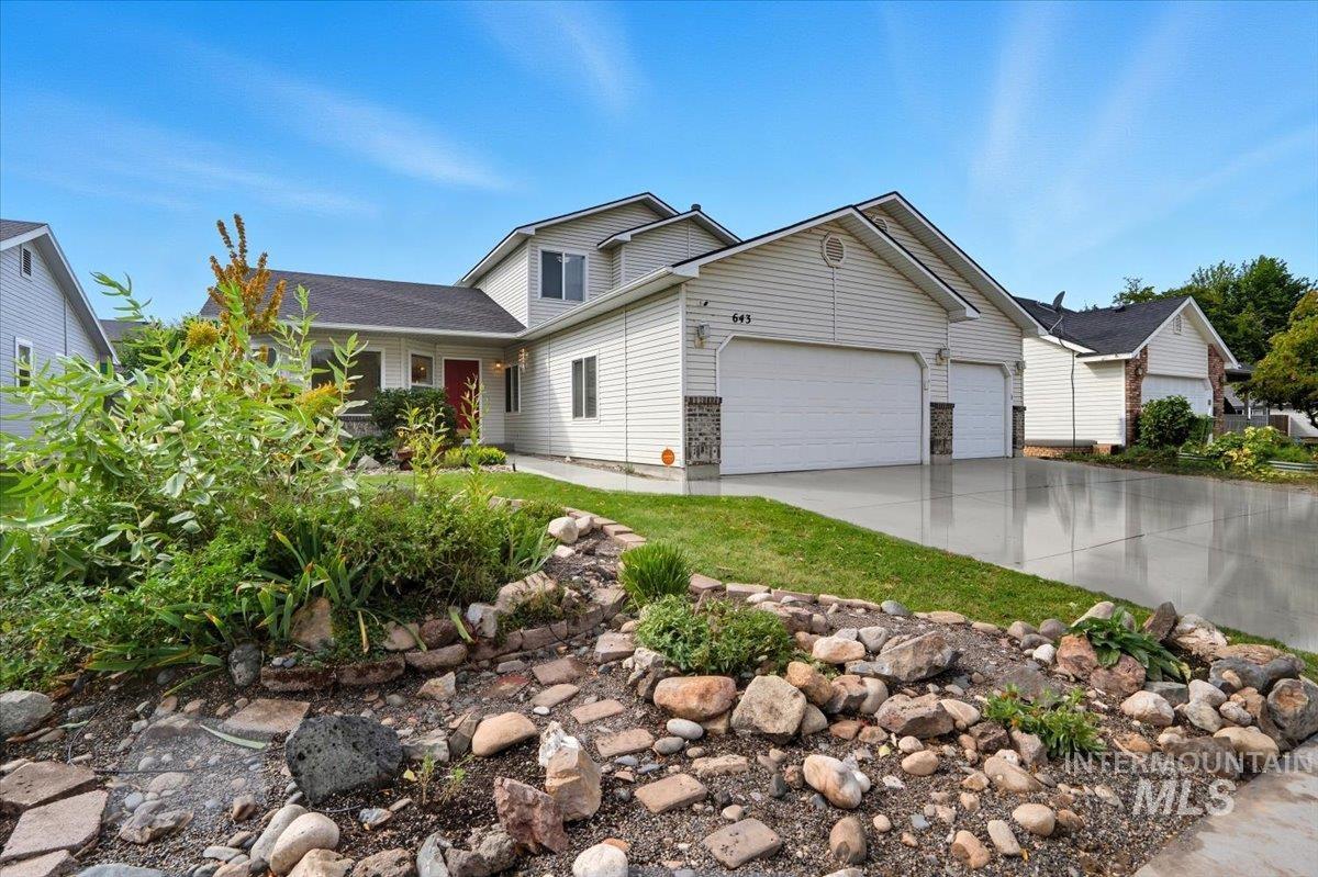 View of front facade with concrete driveway and a garage