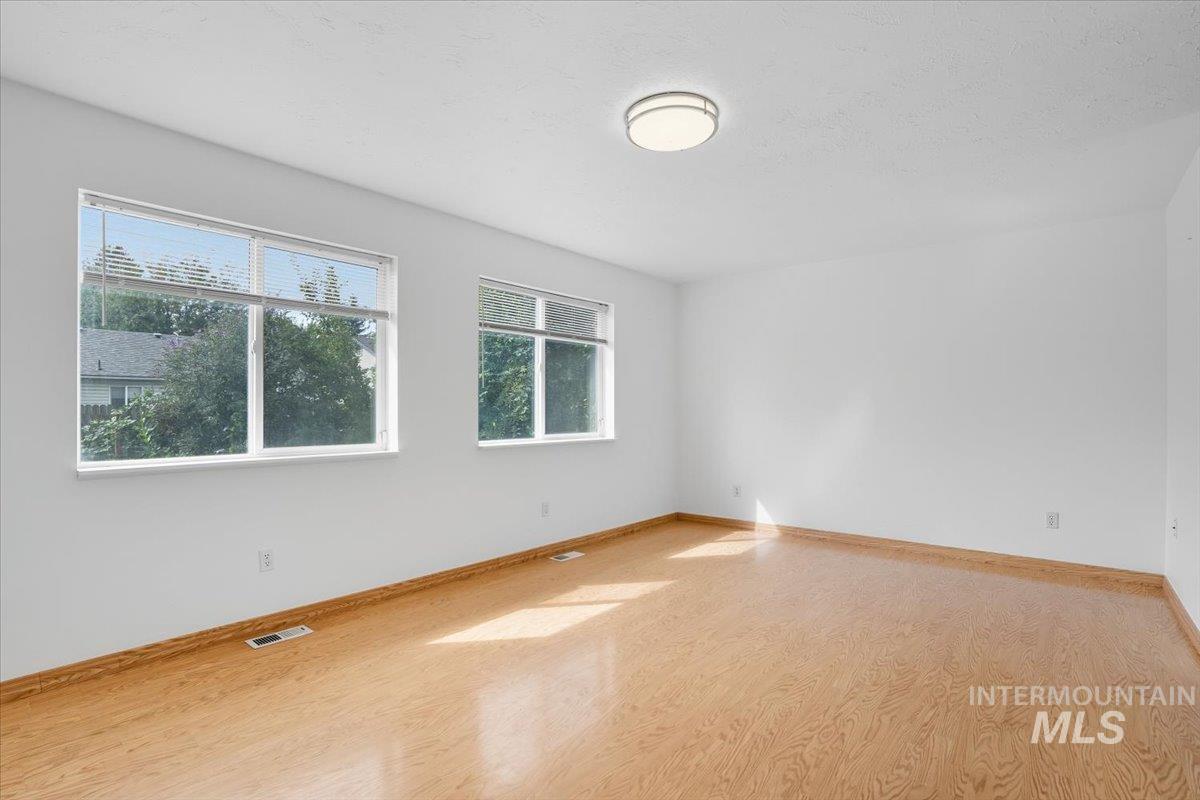 Unfurnished room with wood finished floors and a textured ceiling