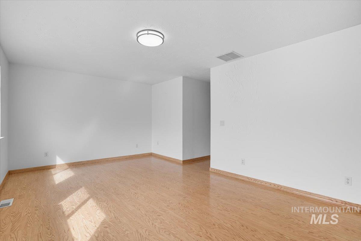 Unfurnished room with light wood-type flooring and baseboards