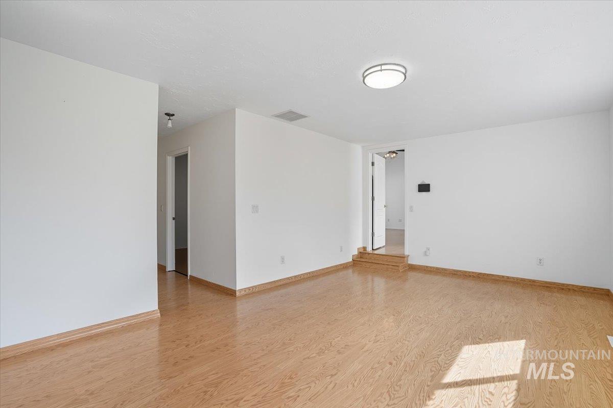Empty room featuring light wood finished floors and baseboards