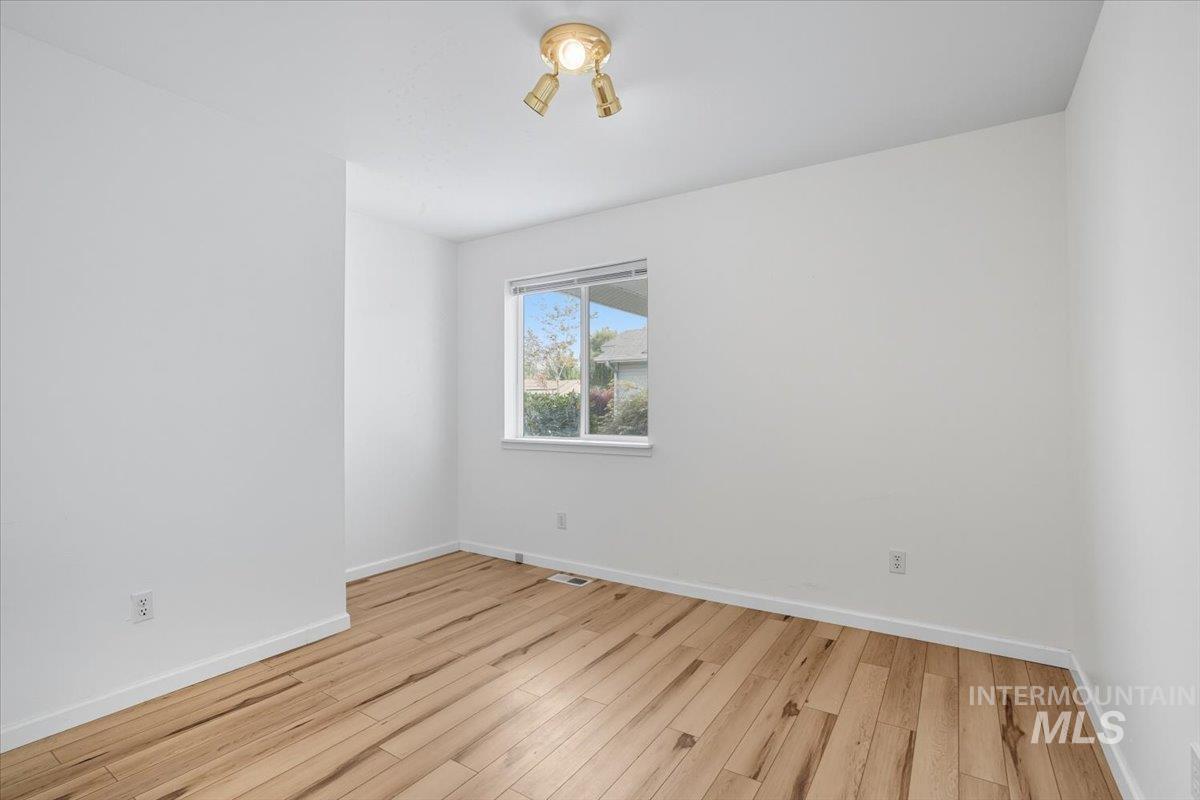 Unfurnished room with baseboards and light wood-style flooring