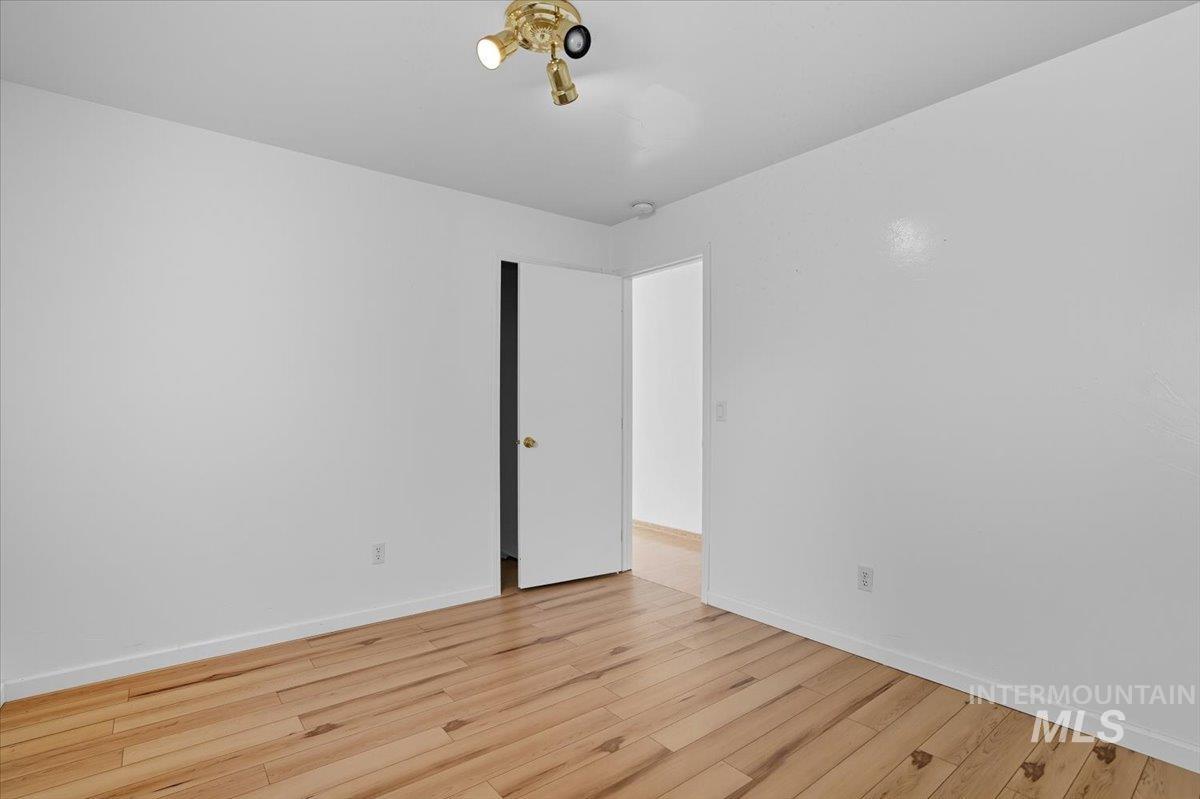 Unfurnished room with light wood-style floors and baseboards