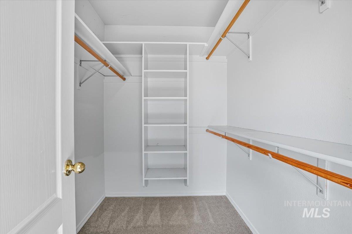 Spacious closet with light colored carpet