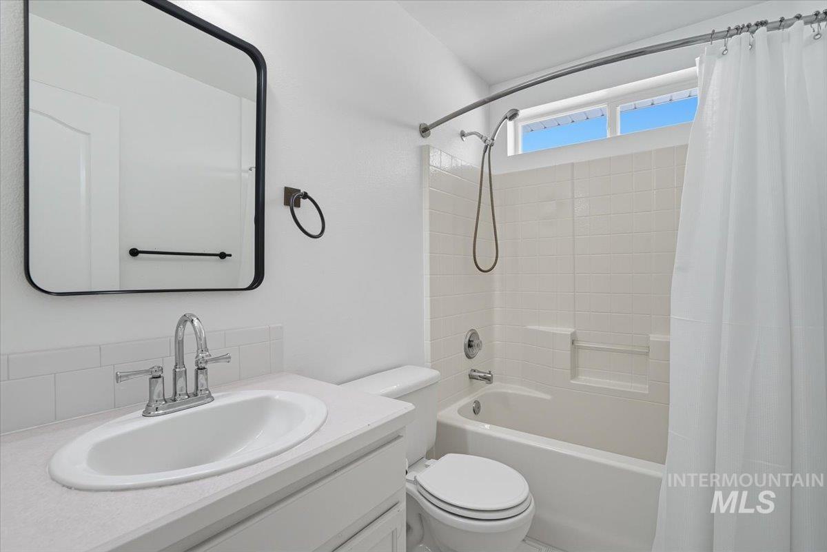 Bathroom featuring shower / bath combination with curtain and vanity