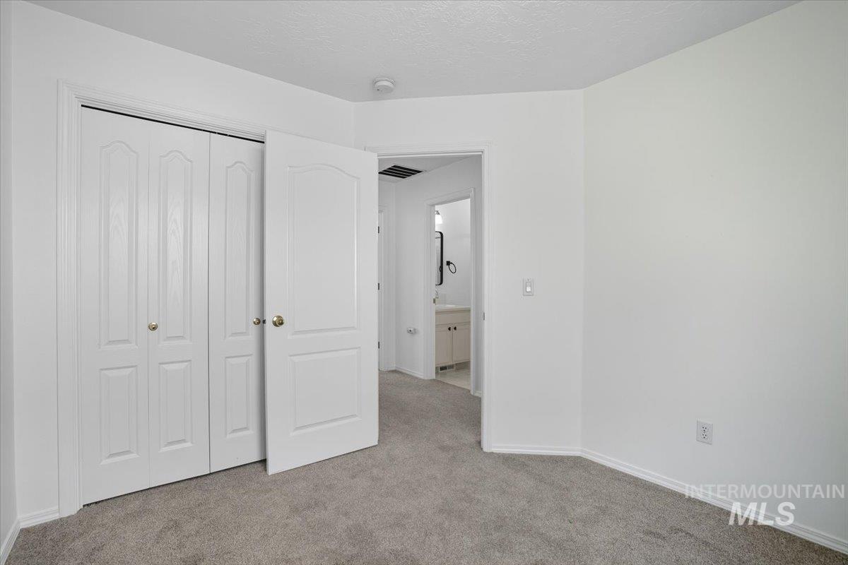 Unfurnished bedroom with carpet flooring, a closet, and a textured ceiling
