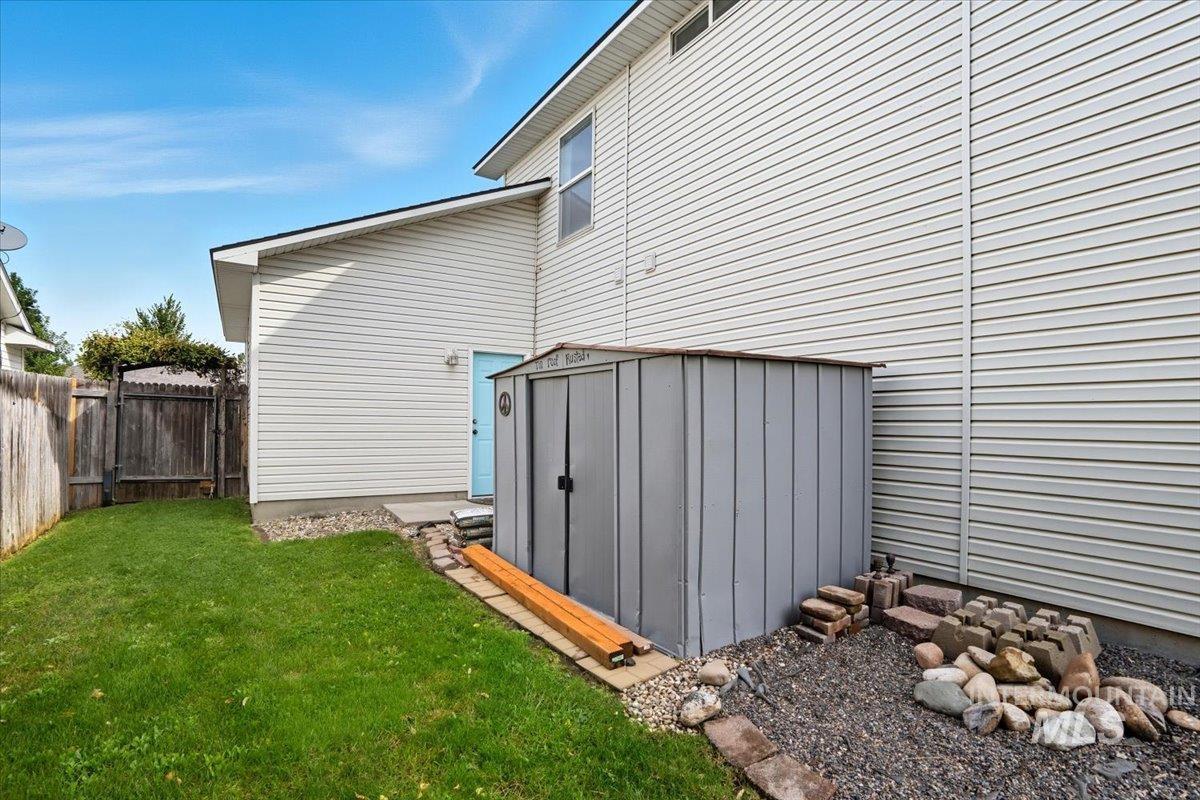 View of home's exterior with a storage unit and a fenced backyard