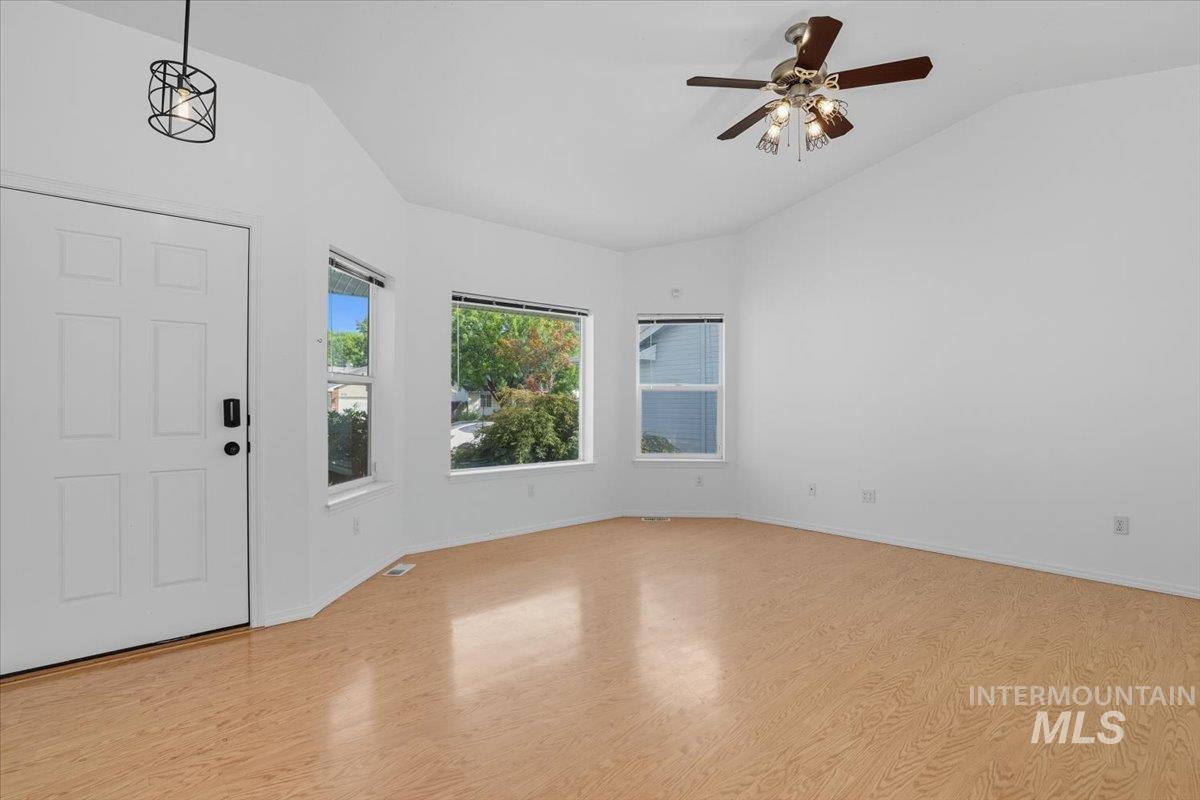 Foyer entrance featuring light wood-type flooring, lofted ceiling, and ceiling fan