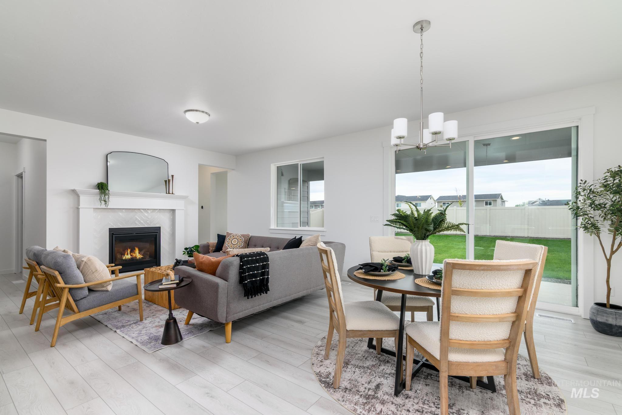 Dining space featuring a high end fireplace, a chandelier, and light wood-style flooring